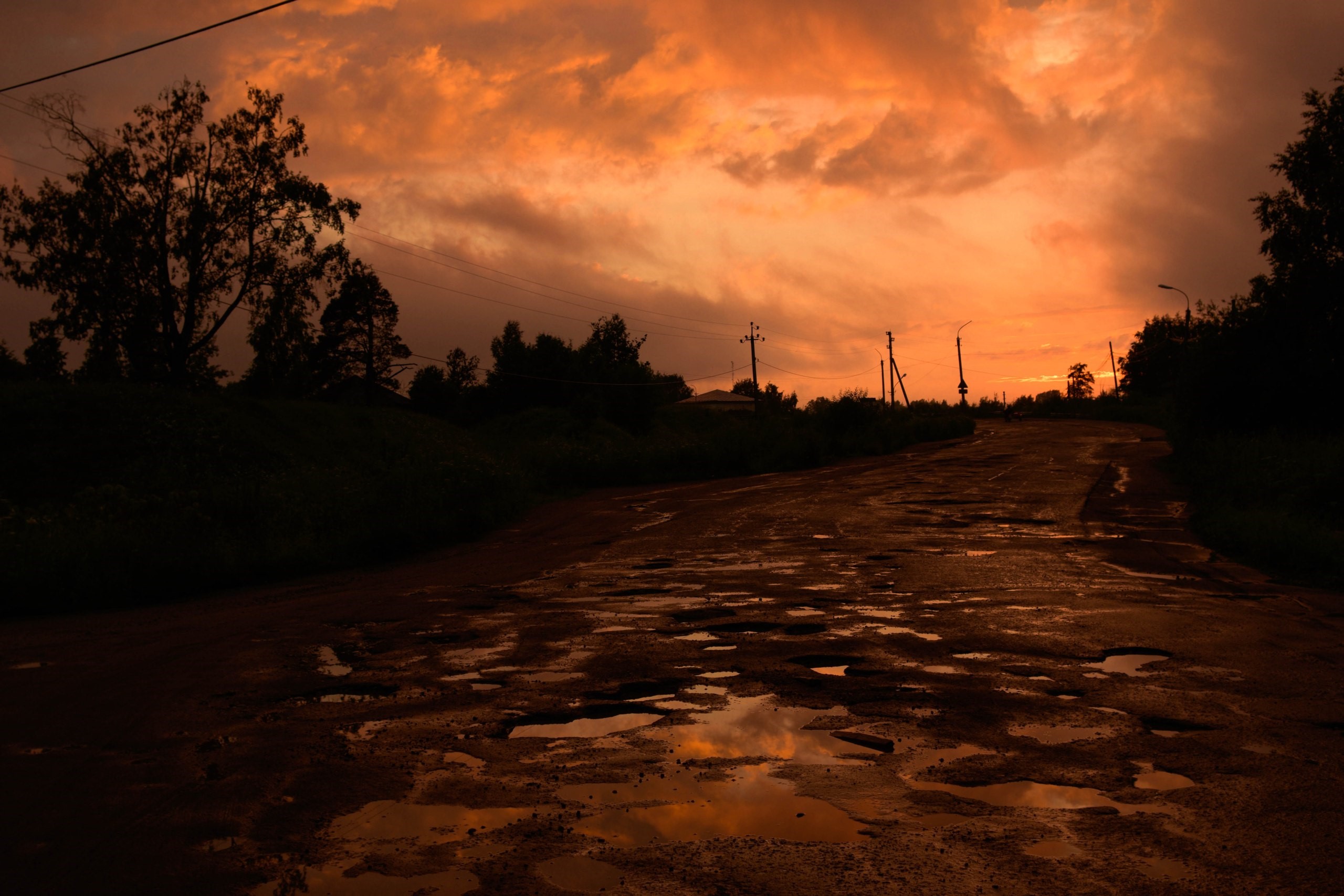 Paved road with puddles at sunset HD Wallpaper