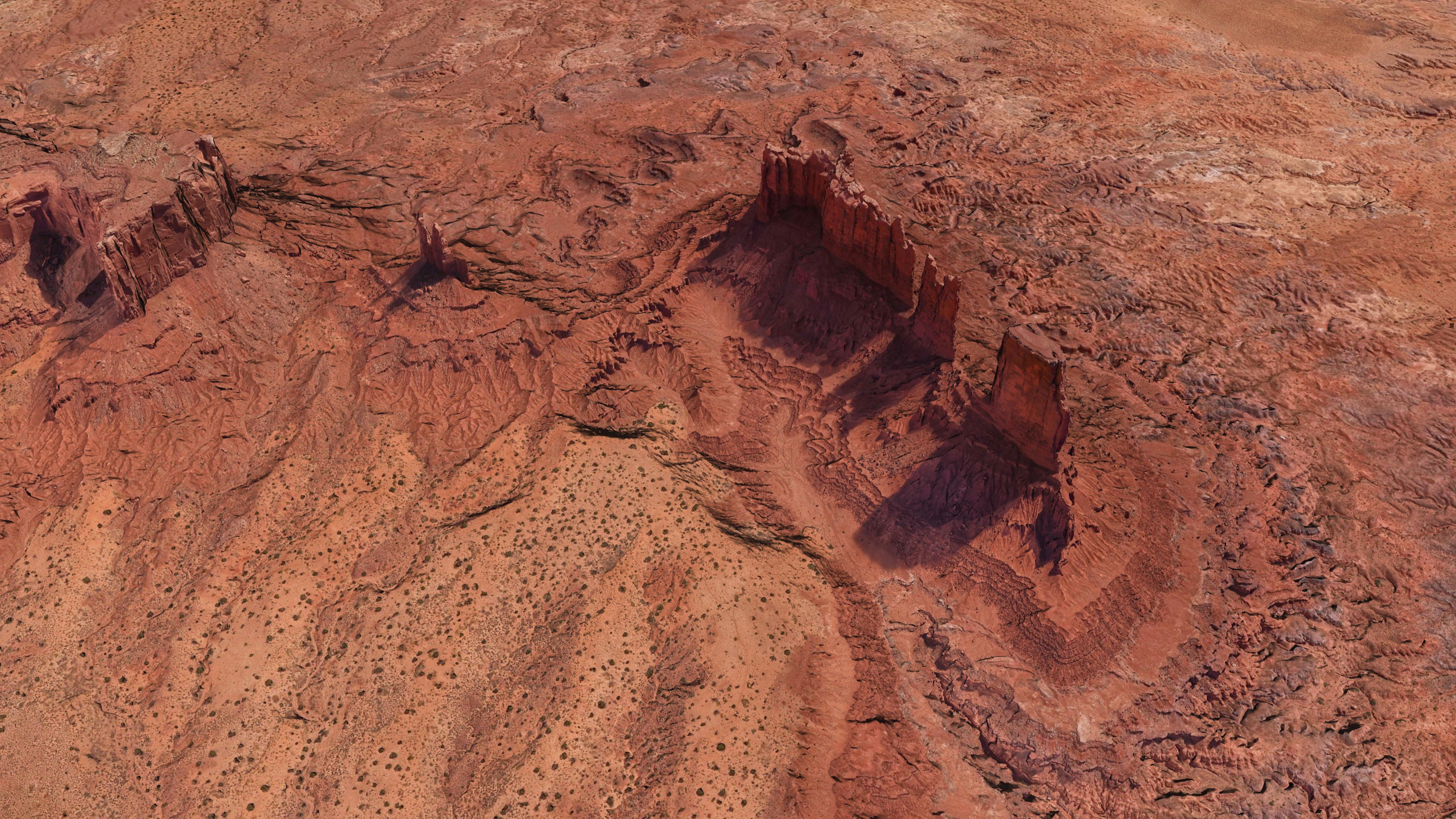 Aerial view of a desert landscape with rock formations HD Wallpaper