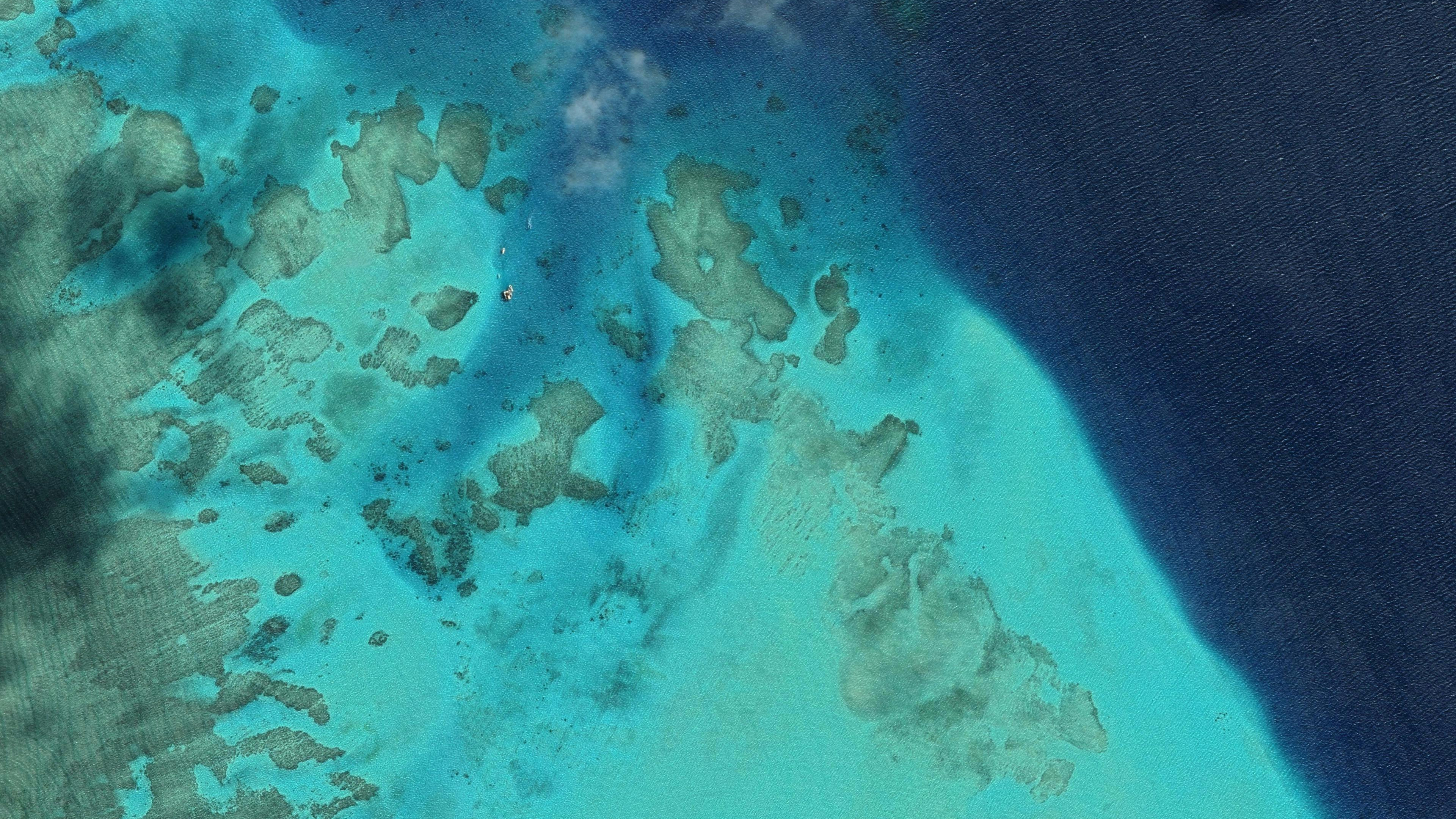 Aerial view of turquoise coral reefs and deep blue sea HD Wallpaper