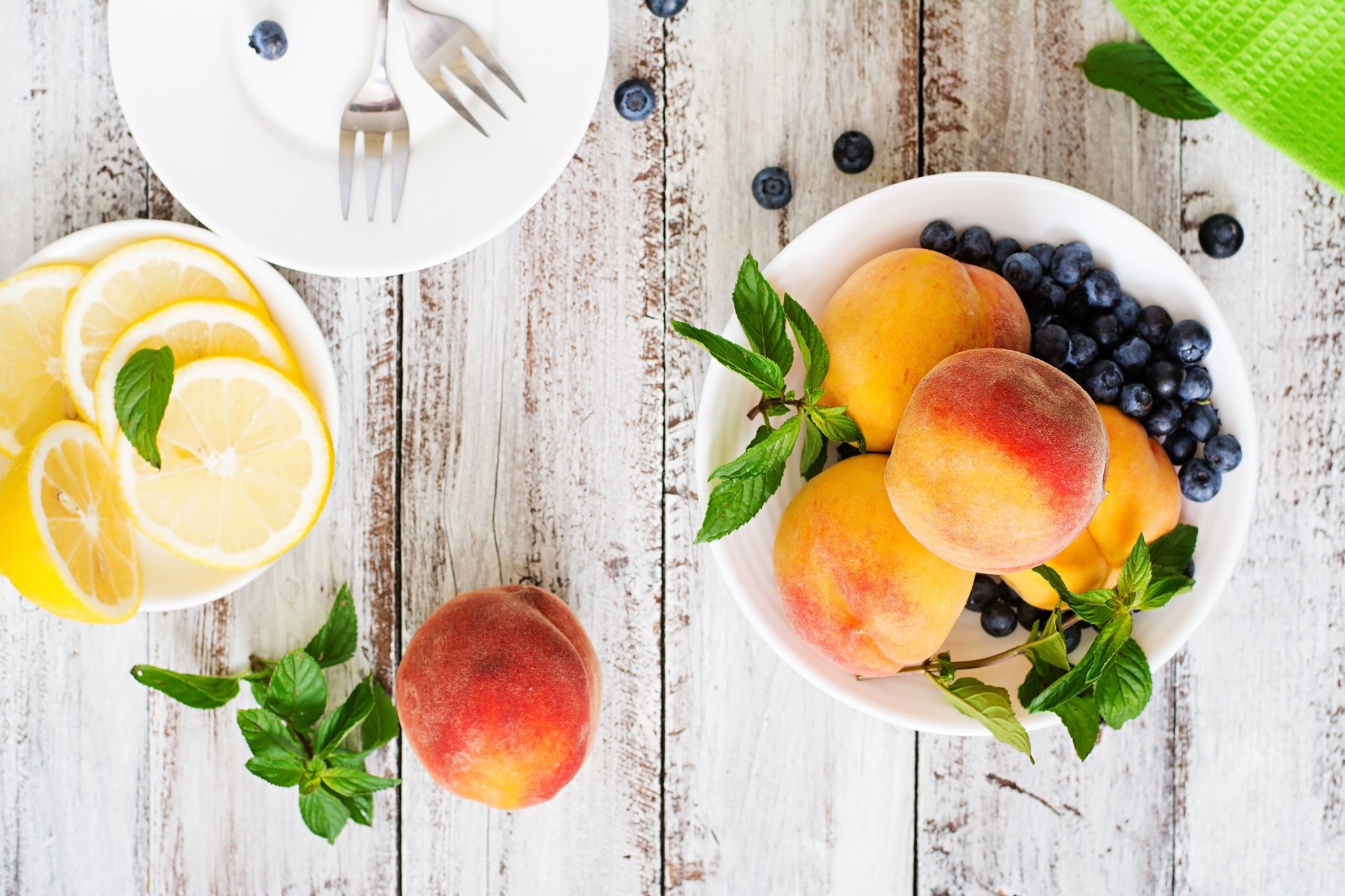 Peaches, blueberries, lemons, and mint on a wooden table HD Wallpaper