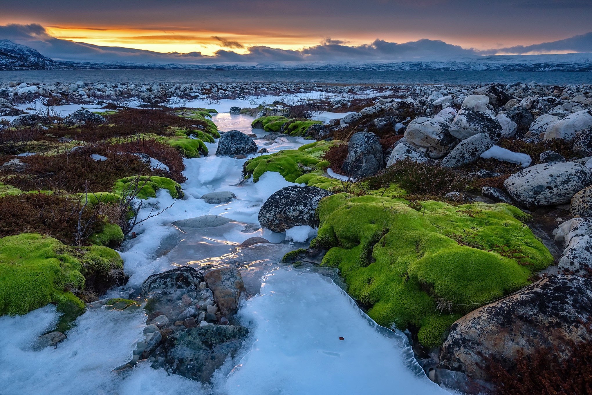 Frozen stream with mossy rocks and sunset sky HD Wallpaper