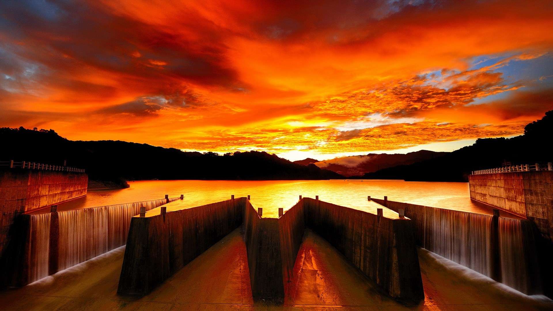 Dam with water flowing at sunset HD Wallpaper