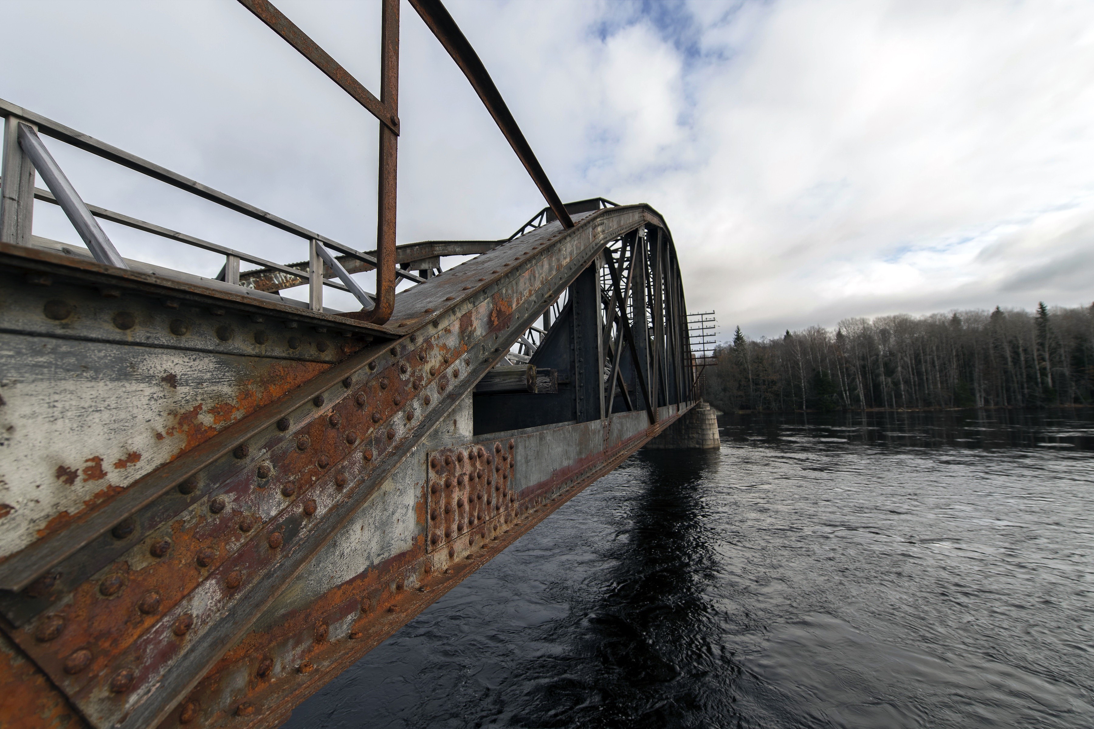 Rusty metal bridge over a dark river HD Wallpaper