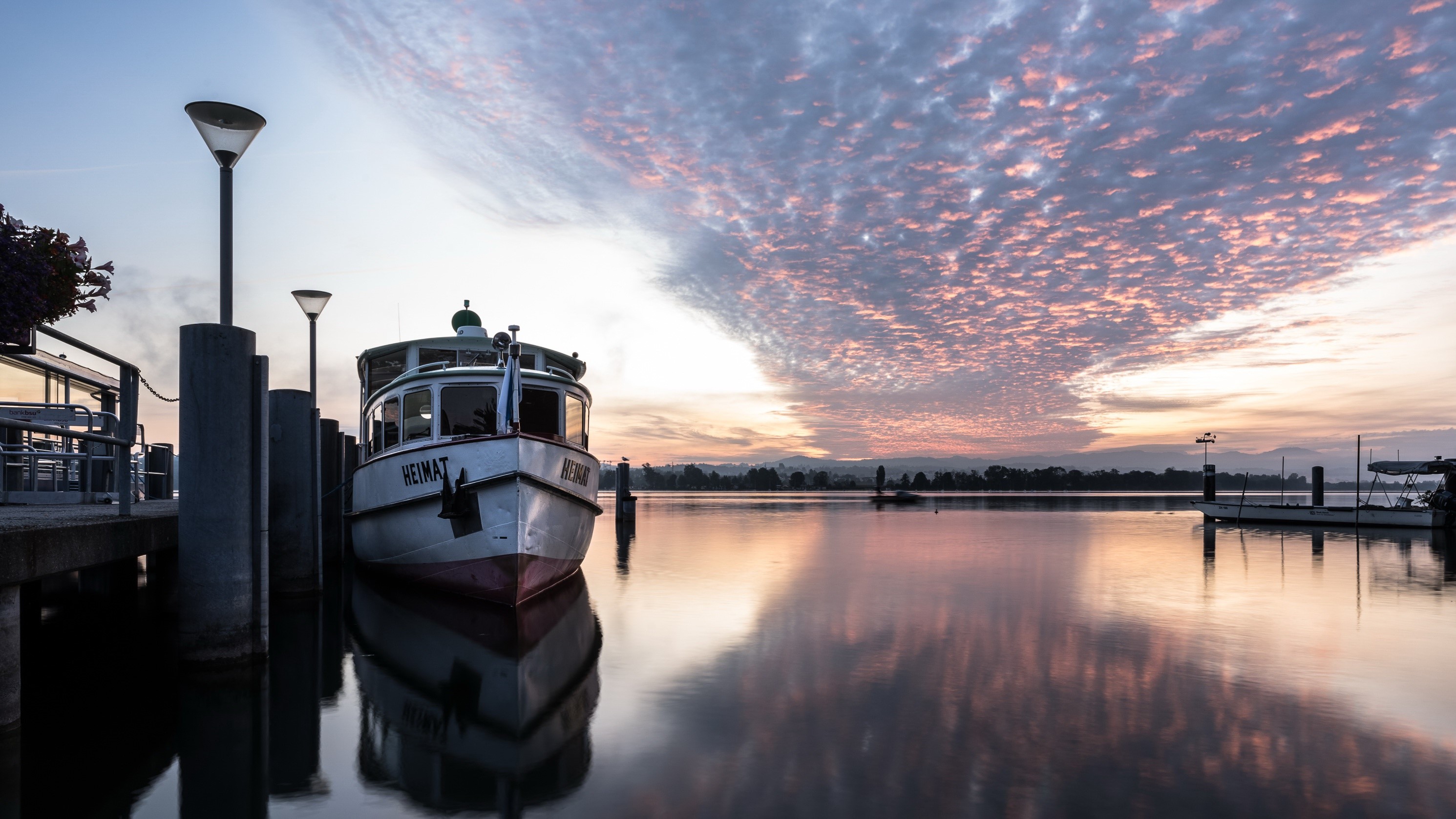 Boat docked at pier during sunset with colorful clouds HD Wallpaper