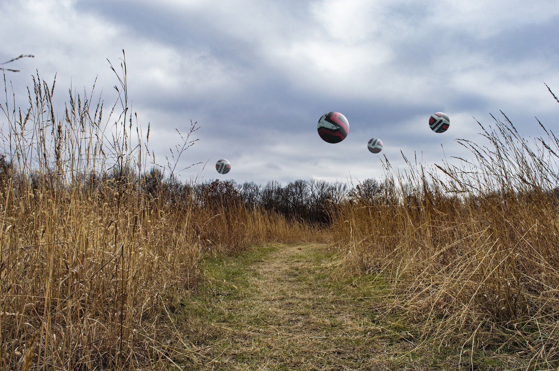 Volleyballs floating over a grassy field HD Wallpaper