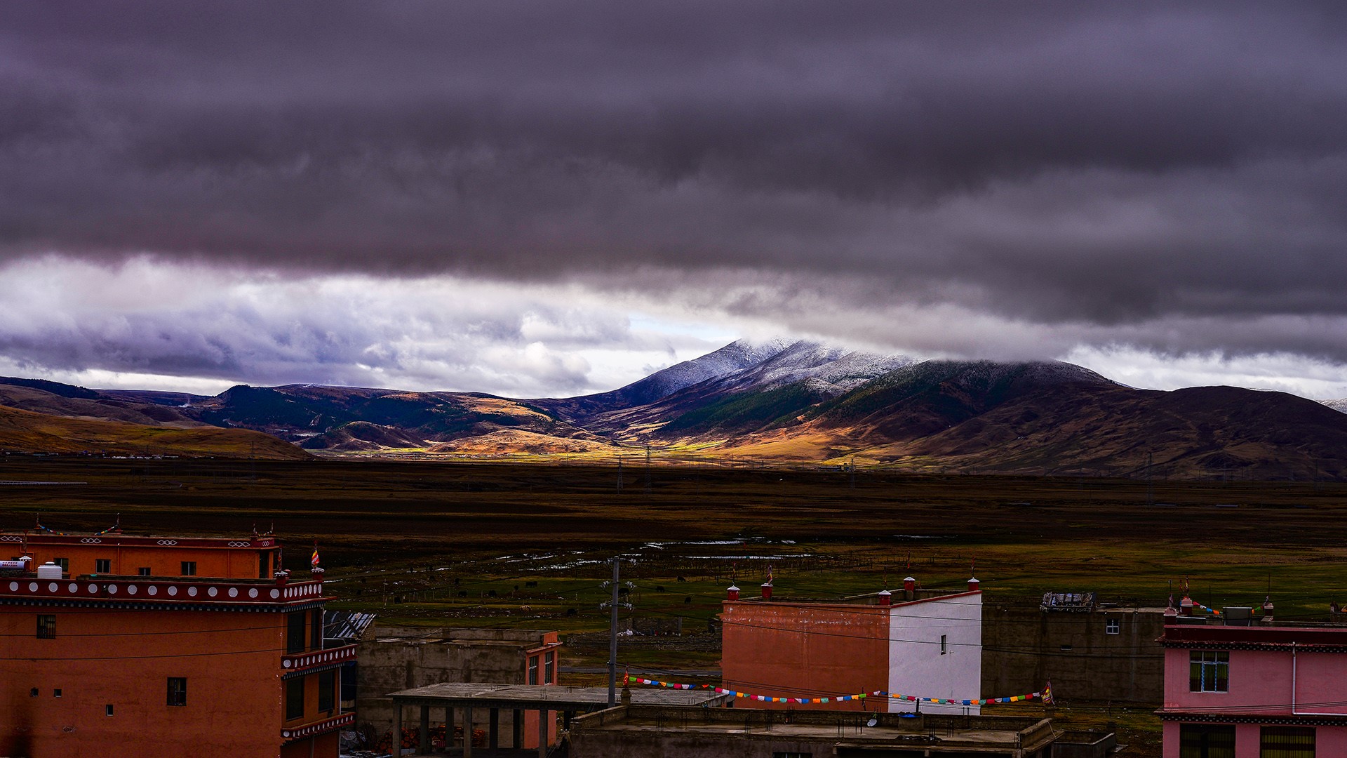 Mountain landscape with buildings under cloudy sky HD Wallpaper