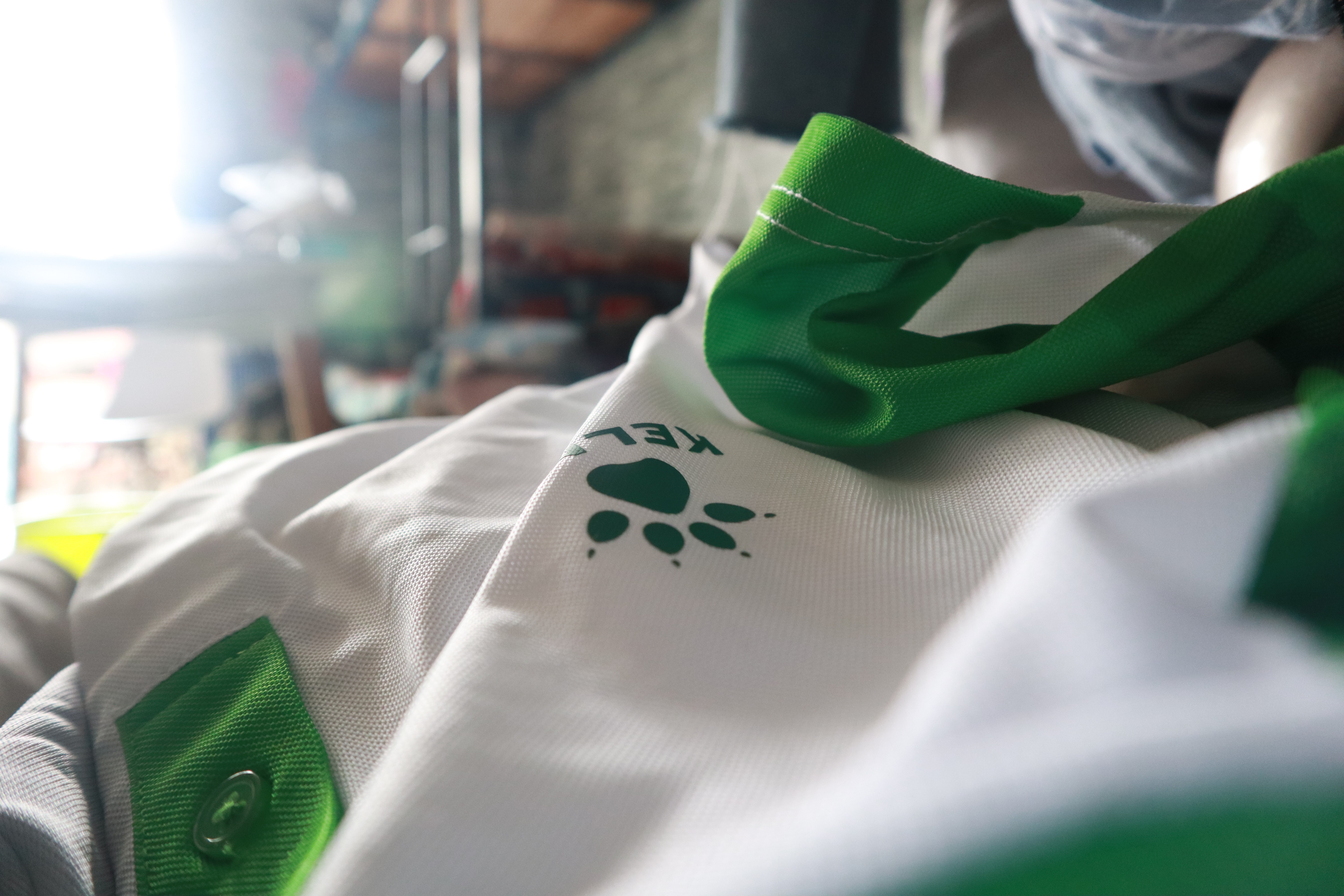 Kelme logo on white and green fabric HD Wallpaper