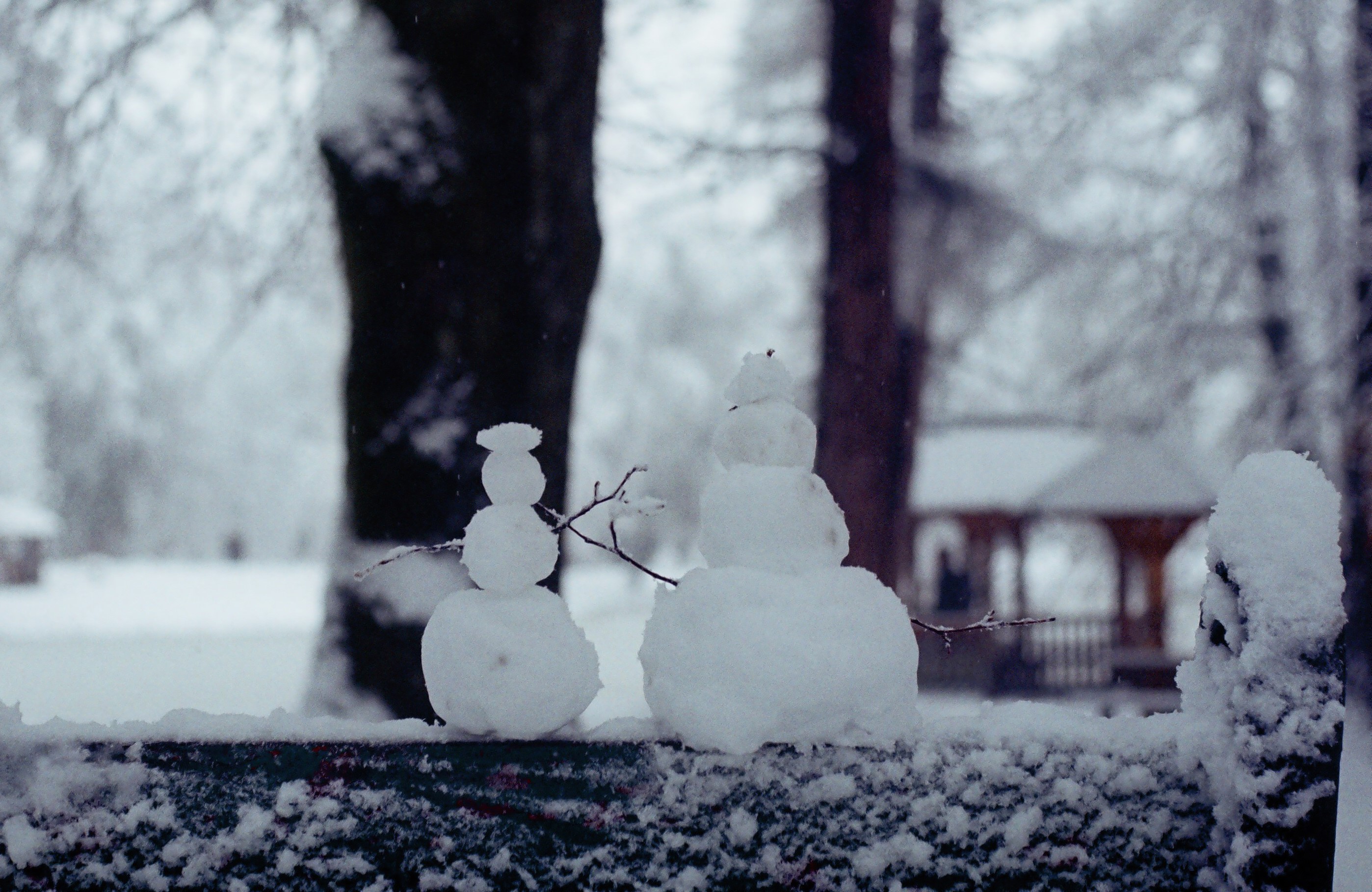 Two snowmen on a snowy fence in winter HD Wallpaper