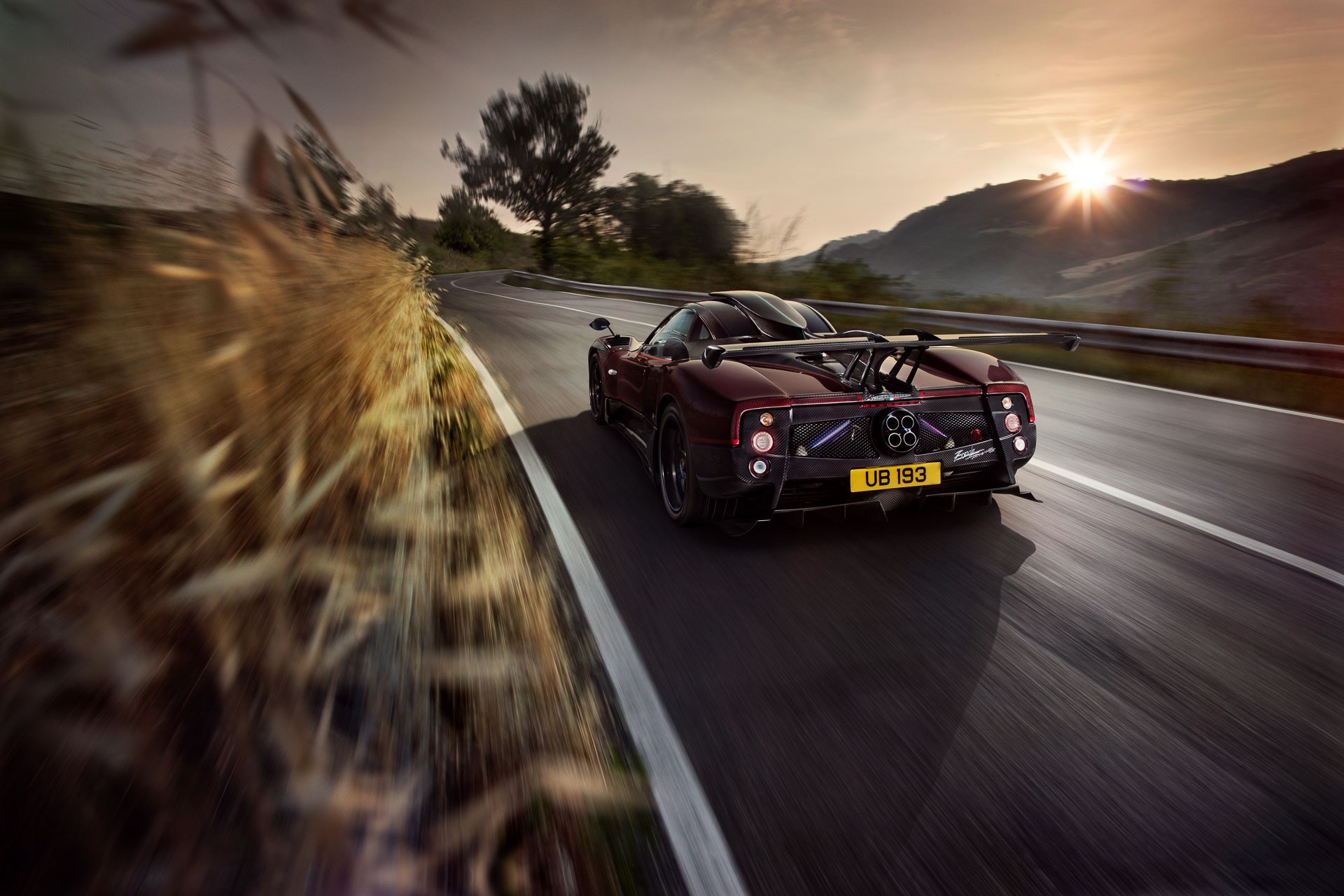 Pagani Zonda driving on a mountain road at sunset HD Wallpaper