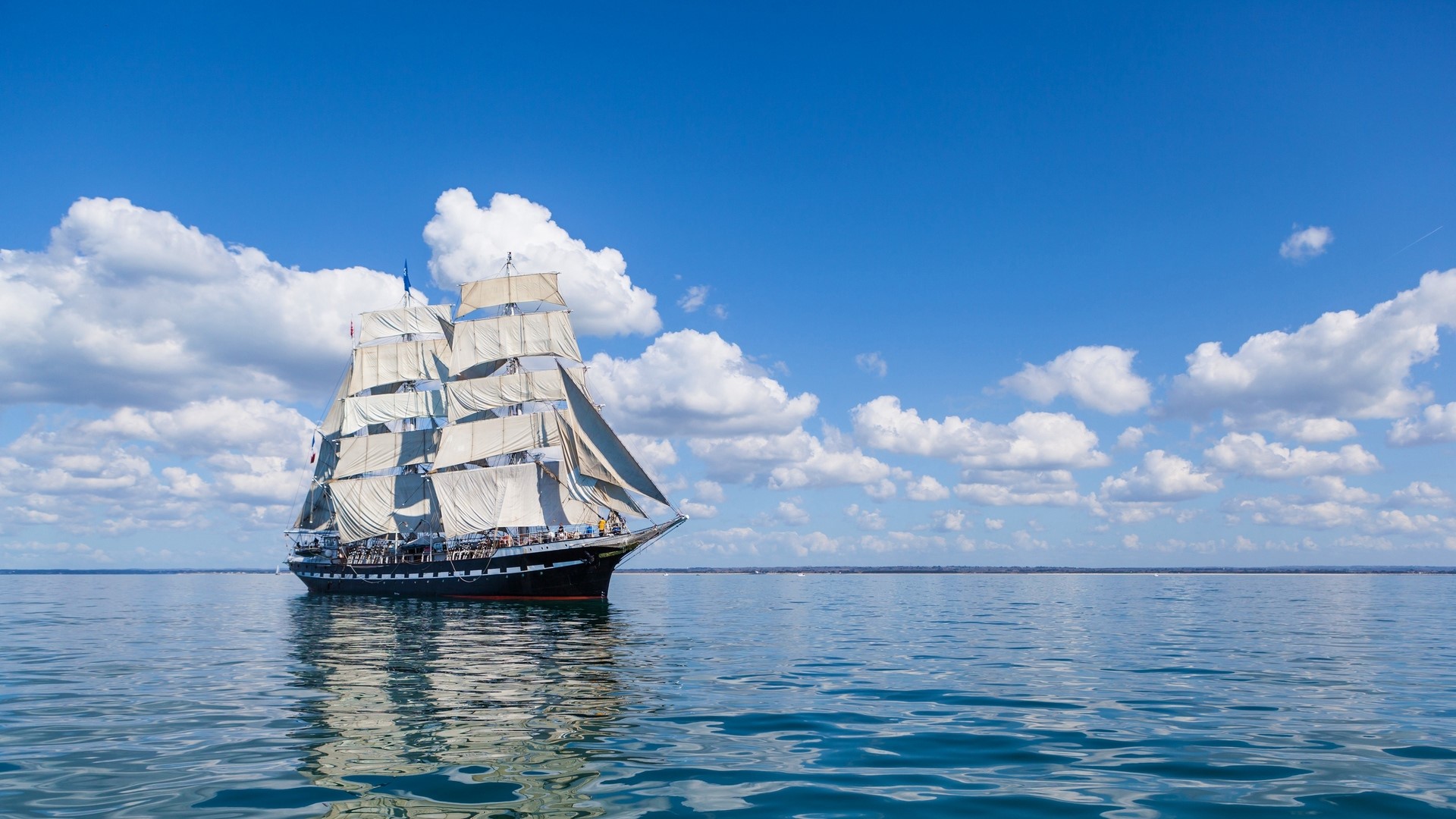 Sailing ship on a calm sea under a blue sky with clouds HD Wallpaper