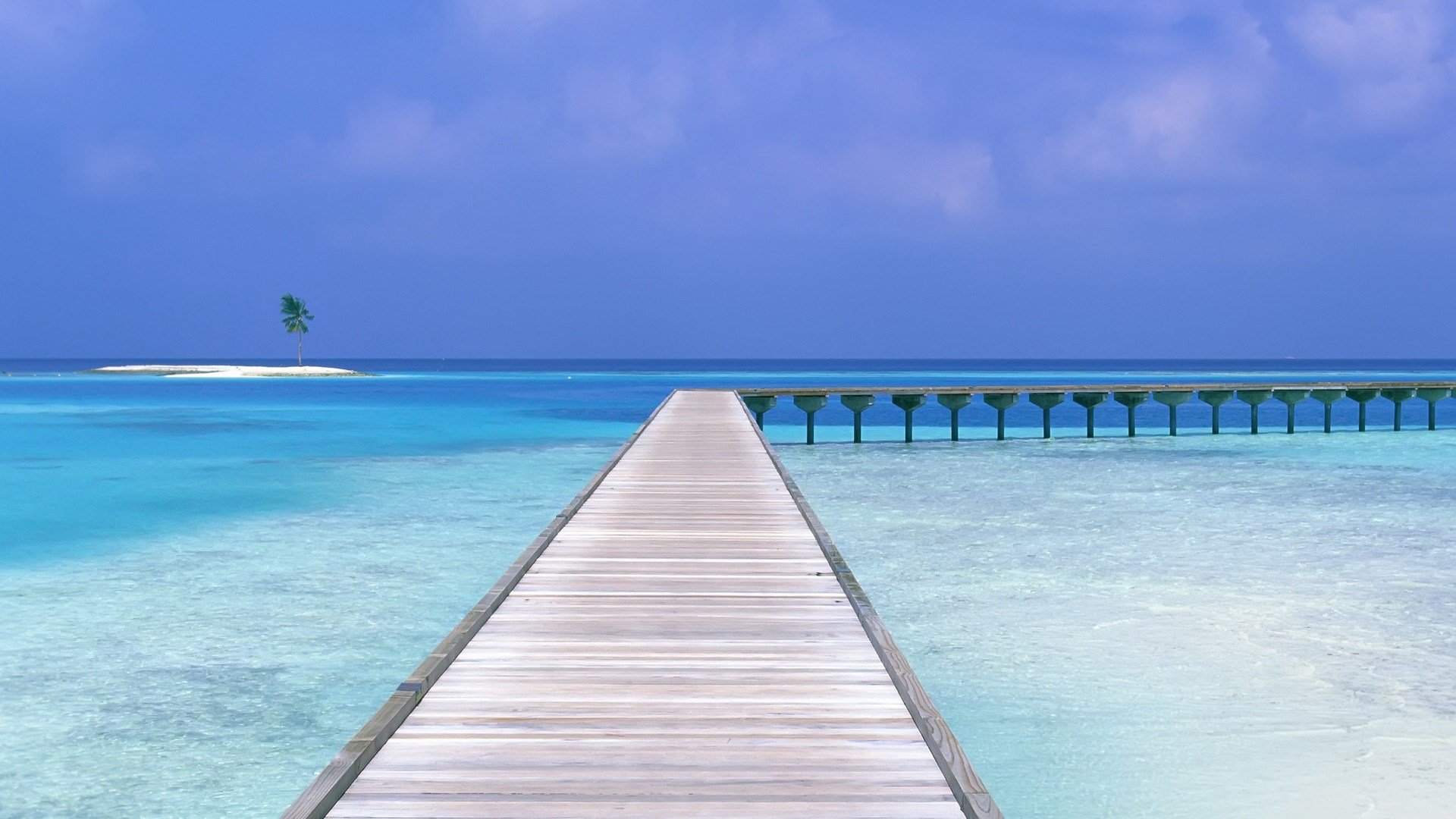 Wooden pier over turquoise water with a small island HD Wallpaper