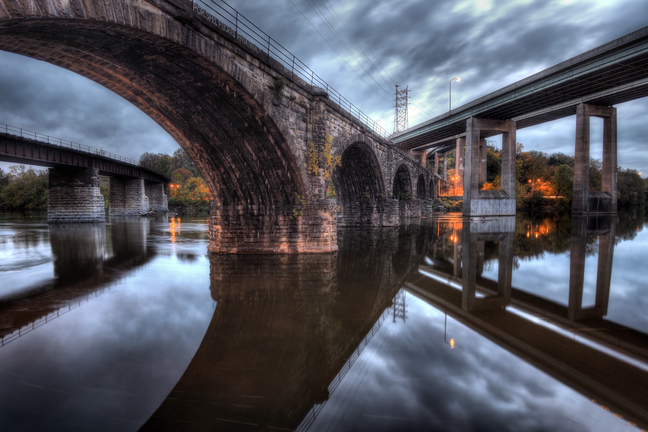 Stone and concrete bridges over a river at dusk HD Wallpaper