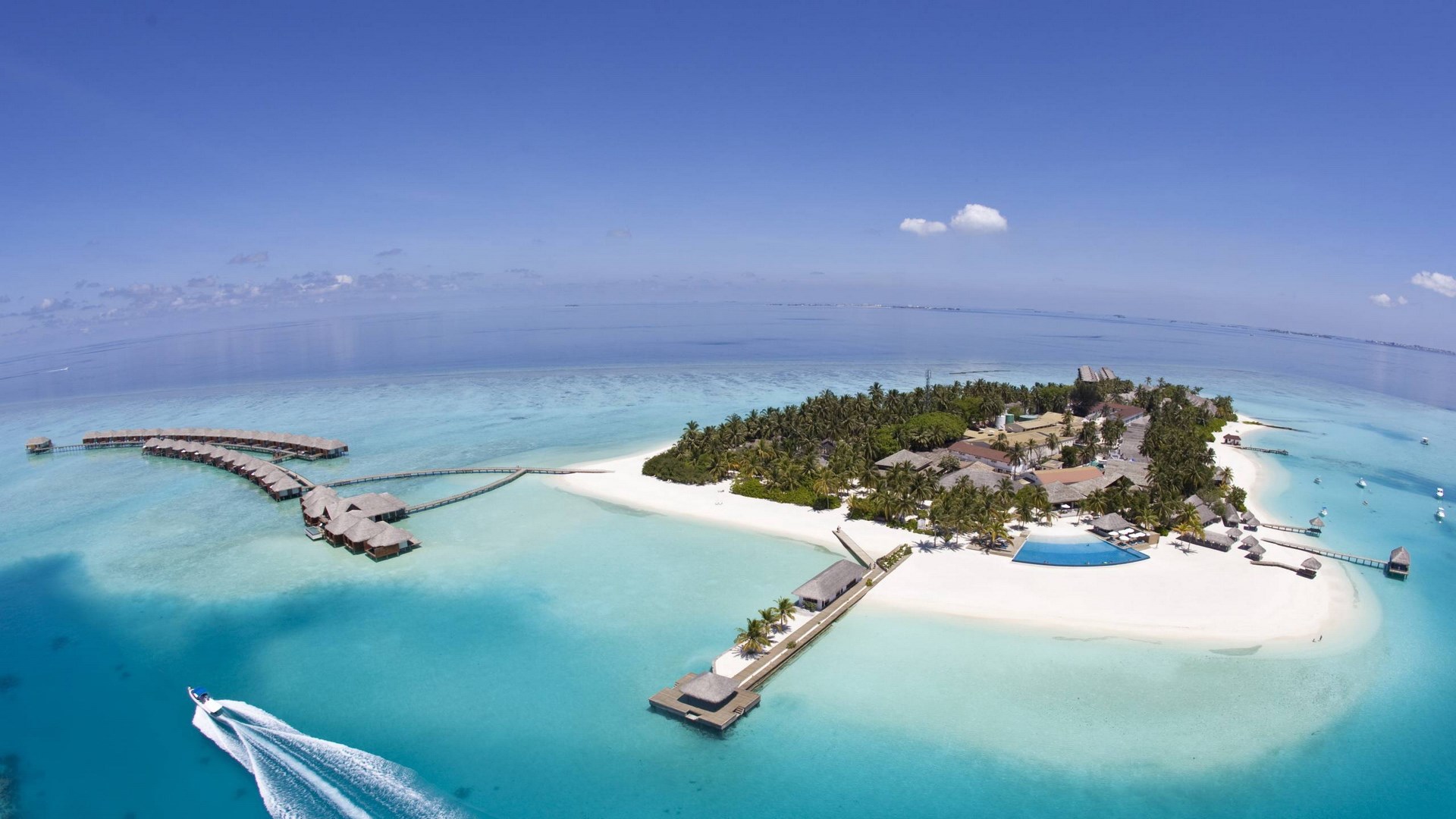 Aerial view of a tropical island resort with overwater bungalows HD Wallpaper