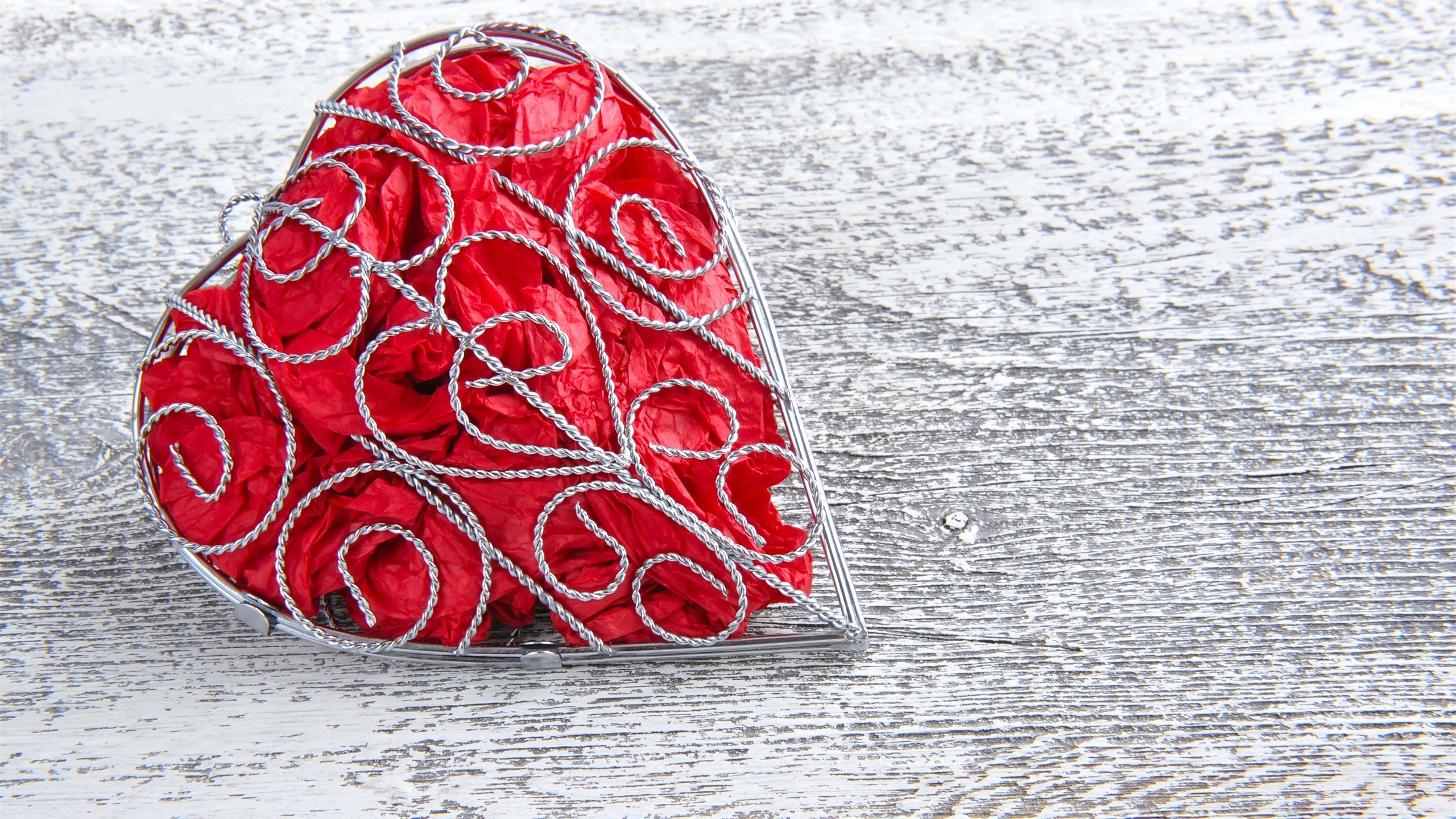 Red heart-shaped box filled with crumpled paper on wood HD Wallpaper