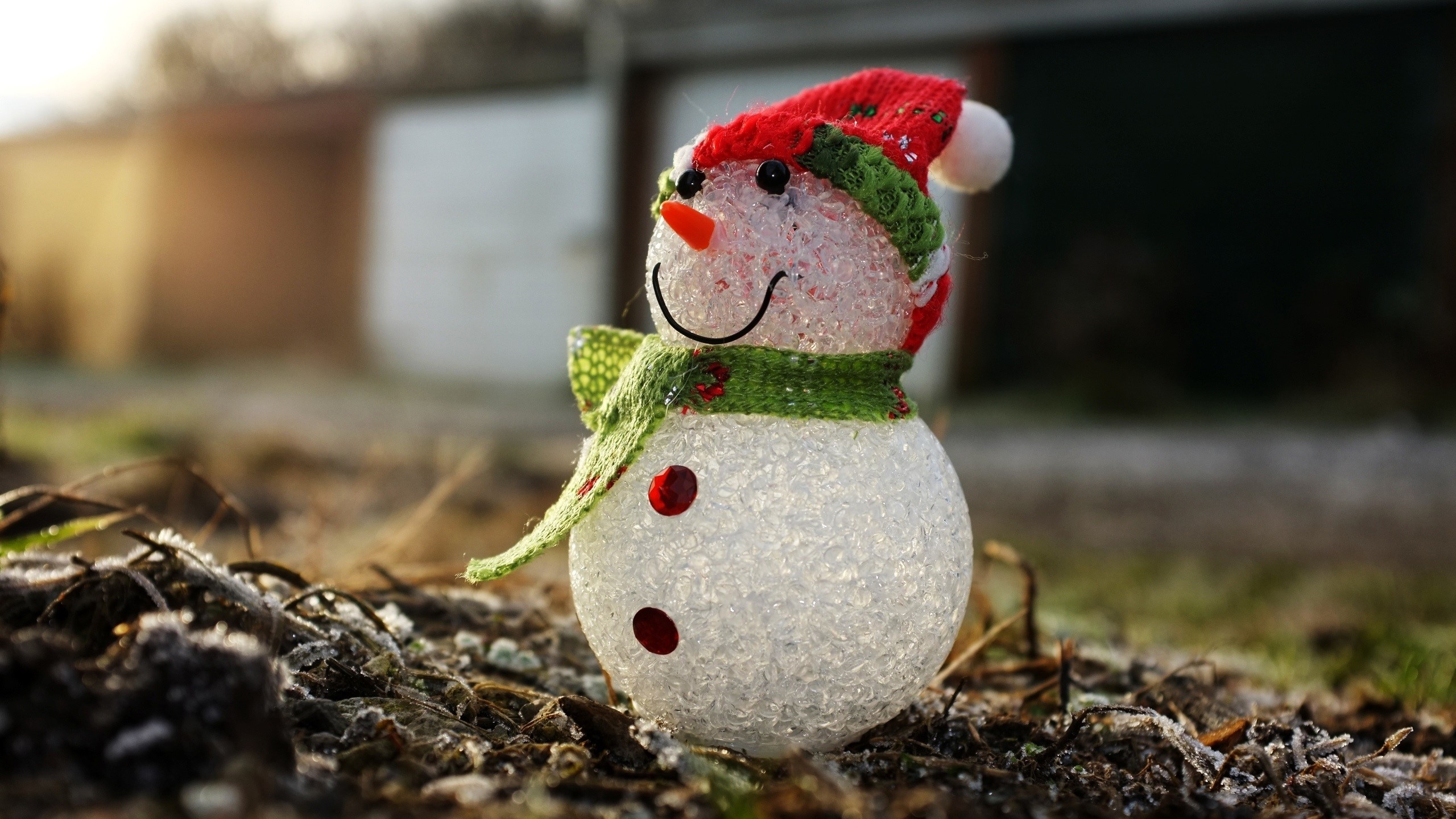 A decorative snowman with a red hat and green scarf HD Wallpaper