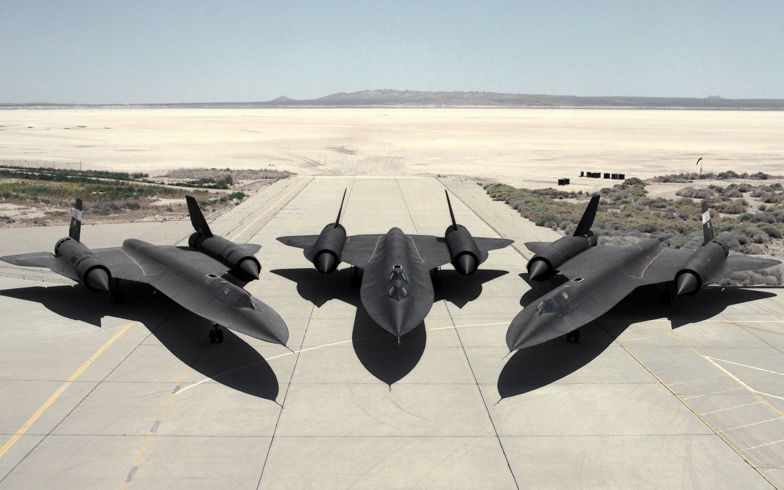 Three Lockheed SR-71 Blackbirds on a desert runway HD Wallpaper