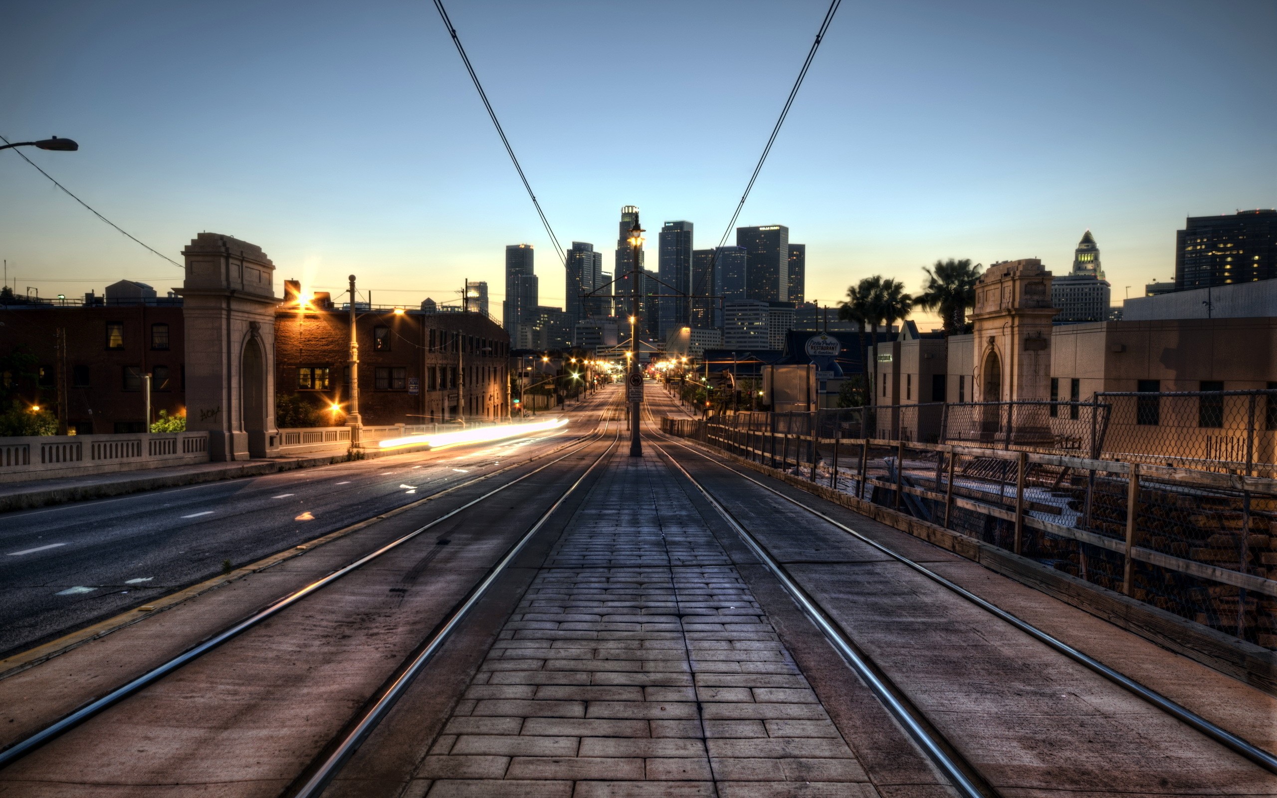 Los Angeles cityscape with tram tracks at dusk HD Wallpaper