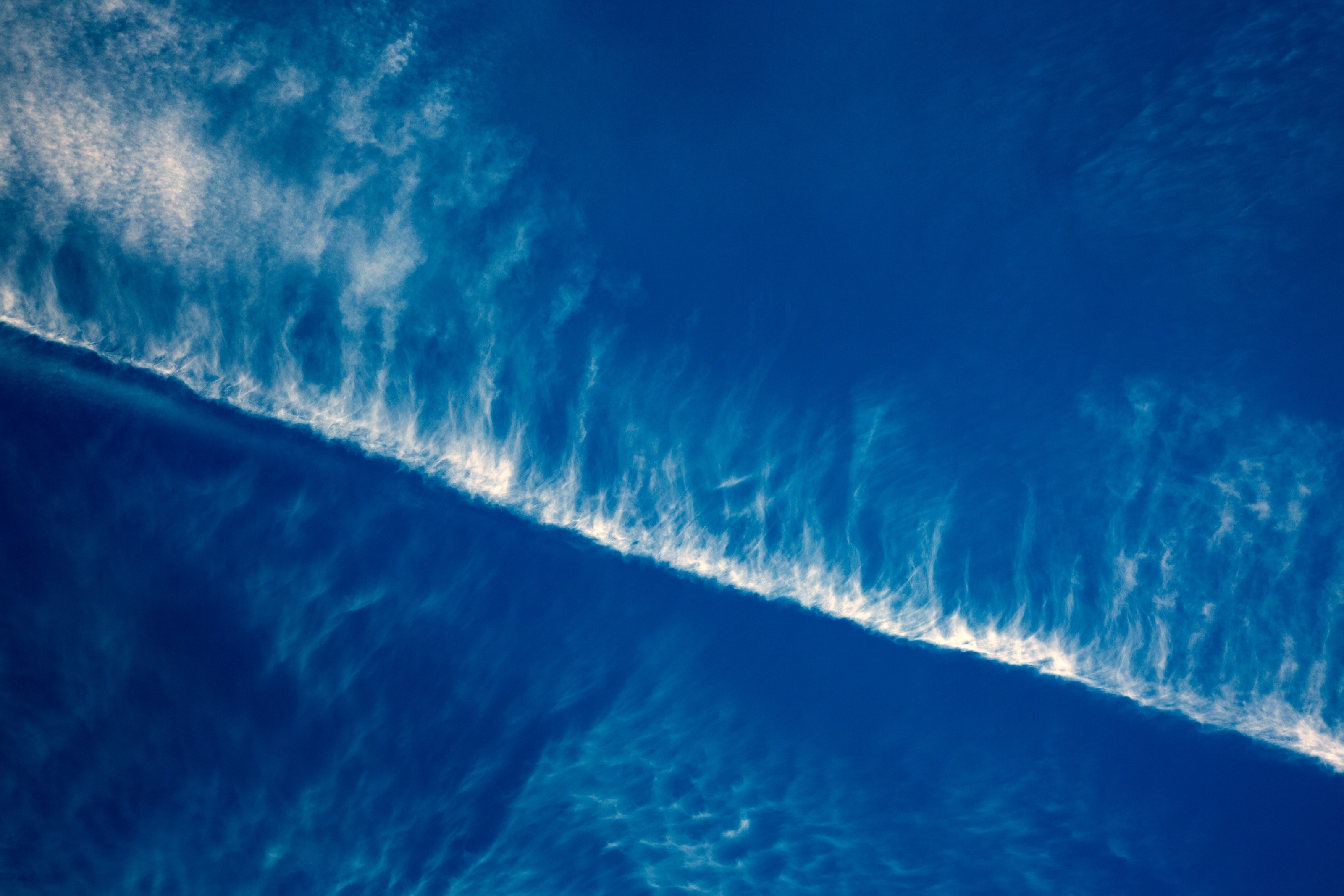Blue sky with wispy white clouds and contrail HD Wallpaper