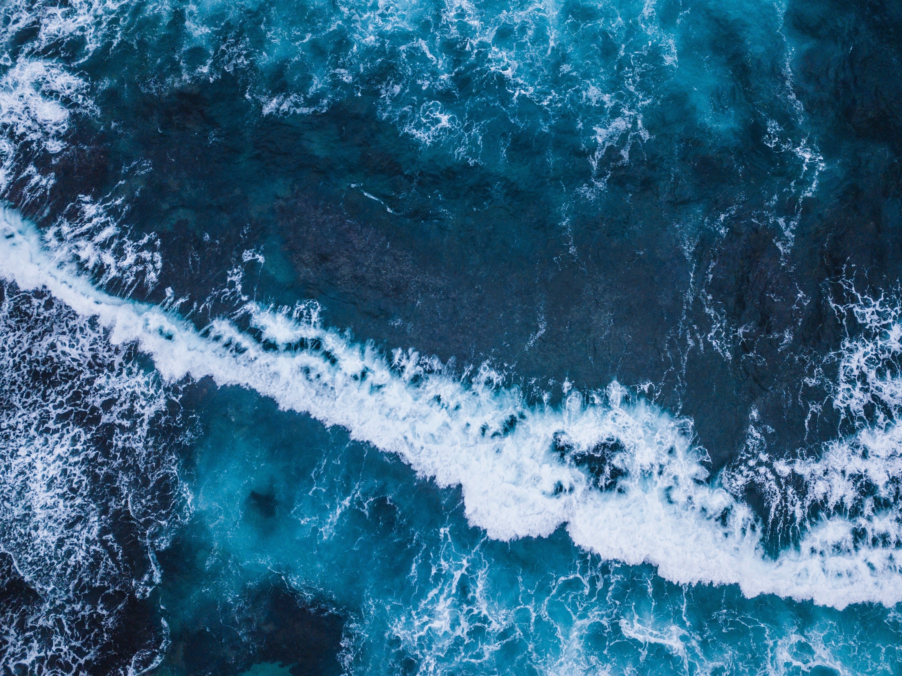Aerial view of ocean waves crashing on shore HD Wallpaper