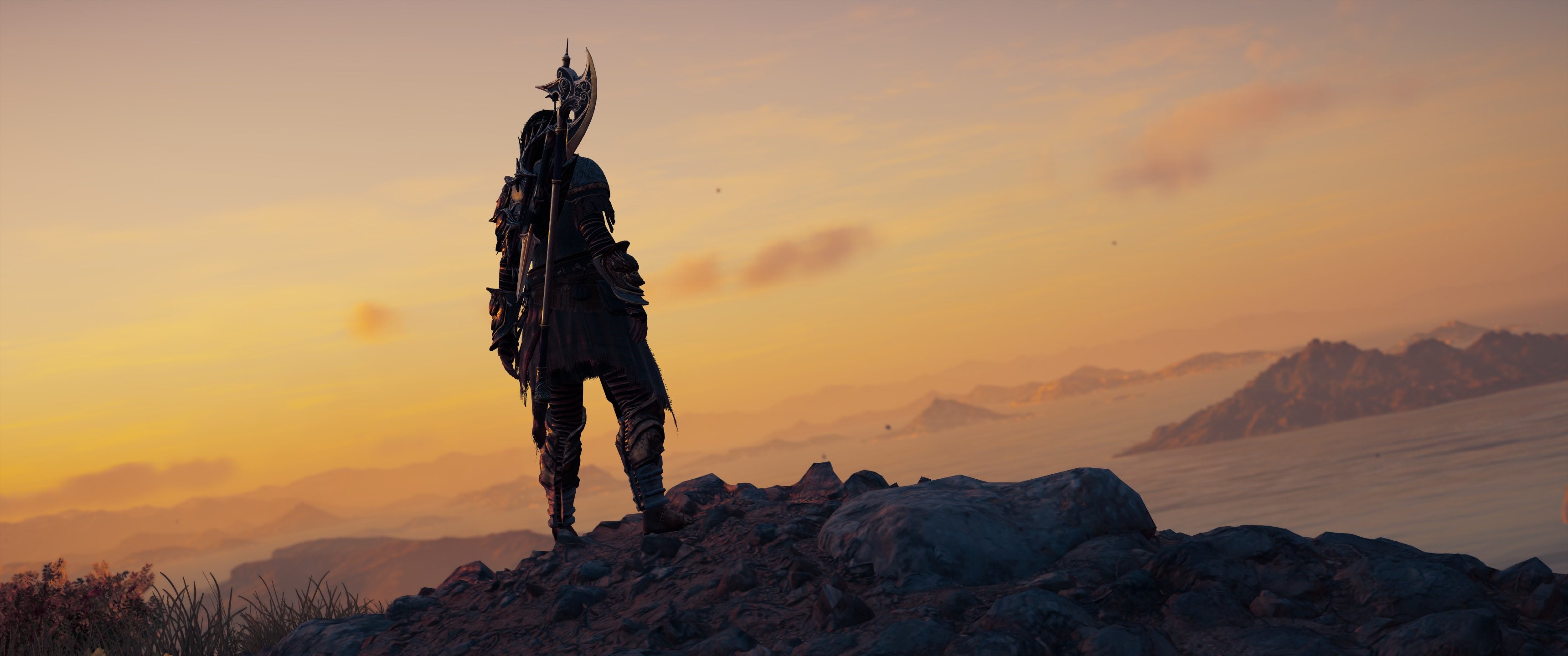 Assassin from Assassin's Creed Odyssey on a mountain at sunset HD Wallpaper