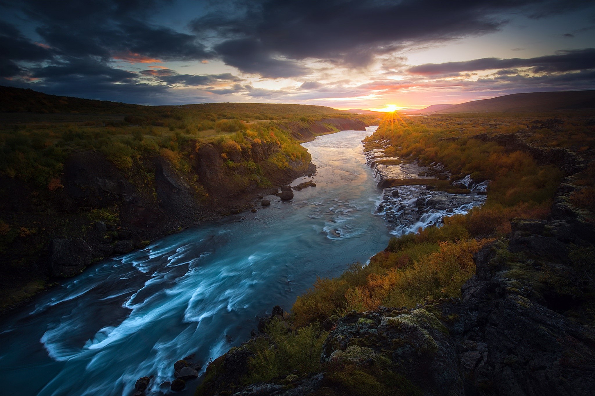 River flowing through a landscape at sunset HD Wallpaper
