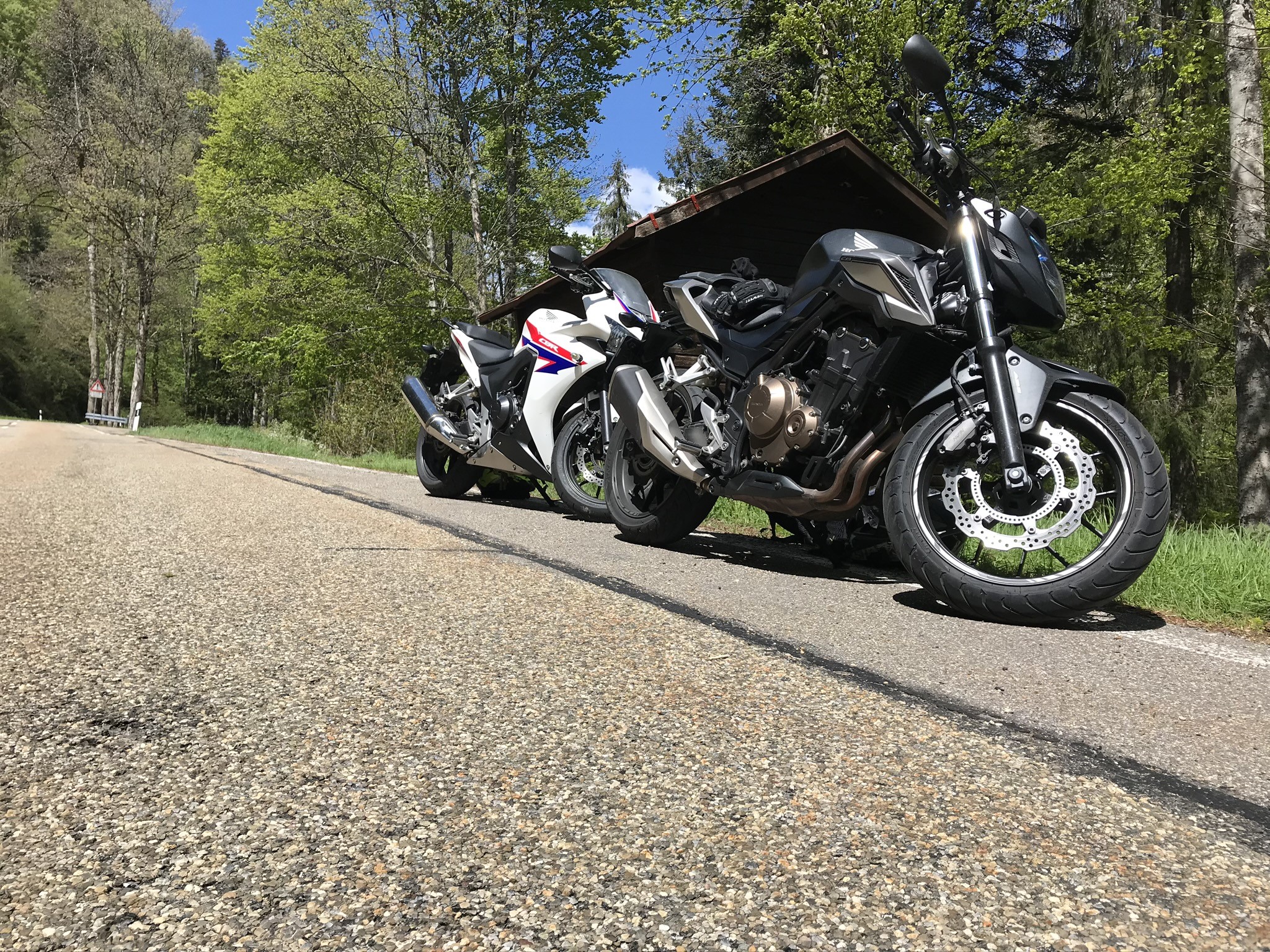 Two Honda motorcycles parked on a road HD Wallpaper
