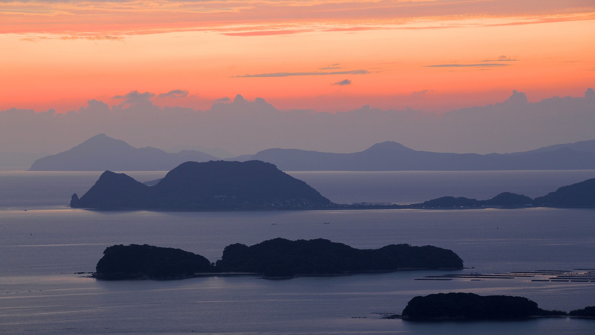 Islands in the sea at sunset with orange sky HD Wallpaper