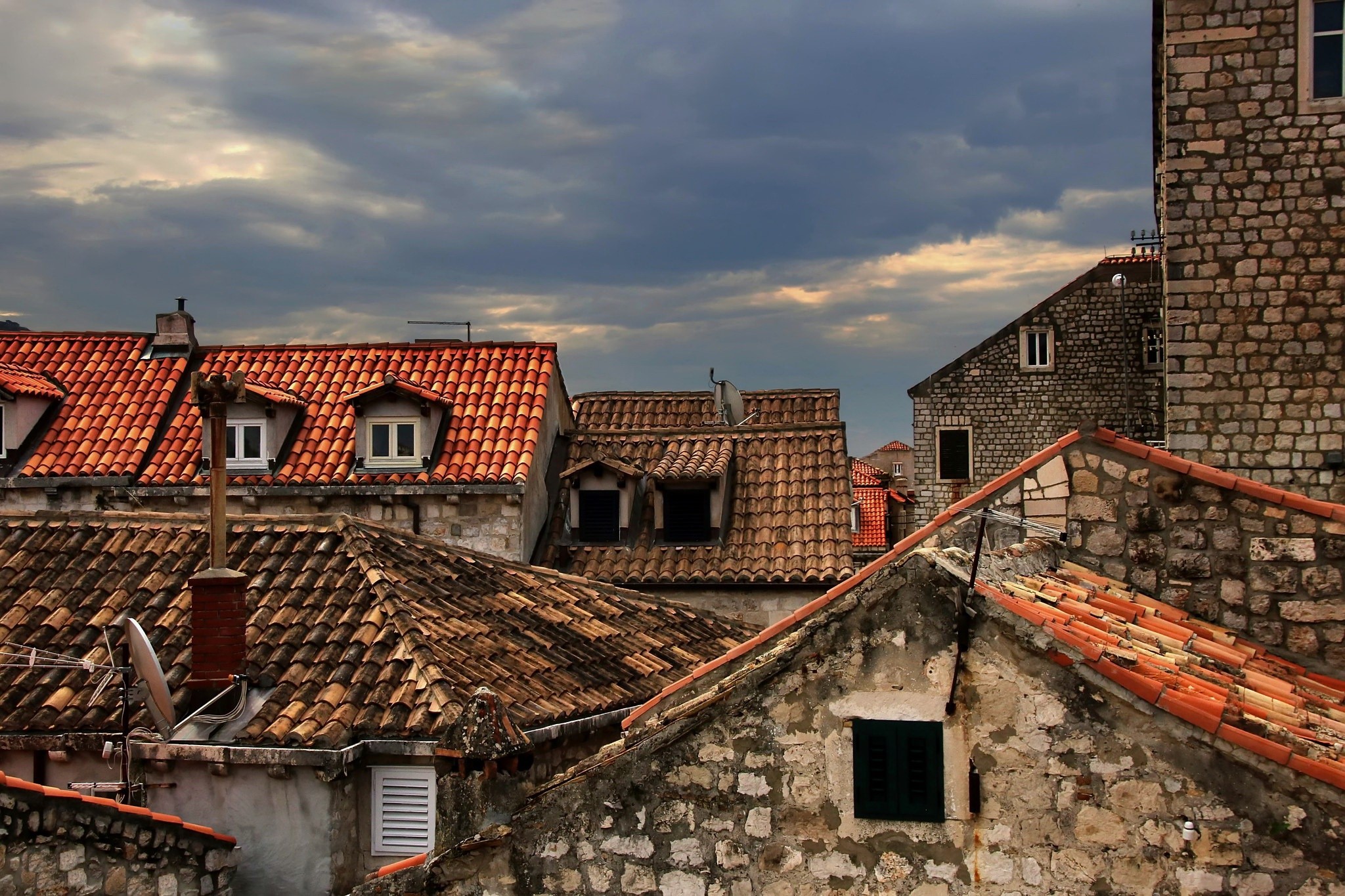 Rooftops of an old European town under a cloudy sky HD Wallpaper