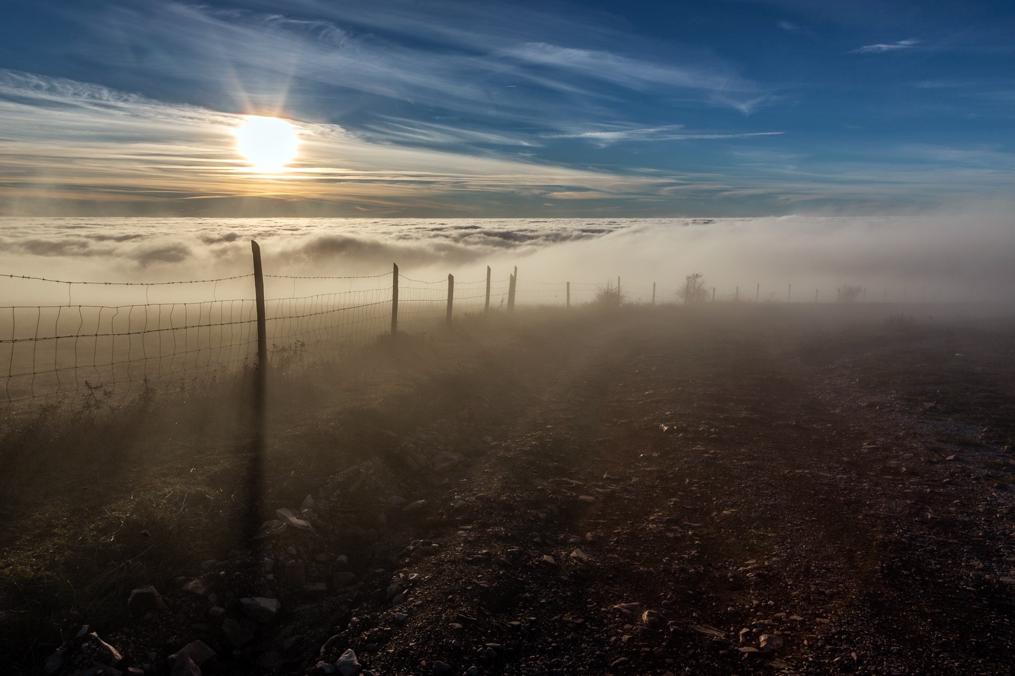 Sun over clouds with fence and fog HD Wallpaper