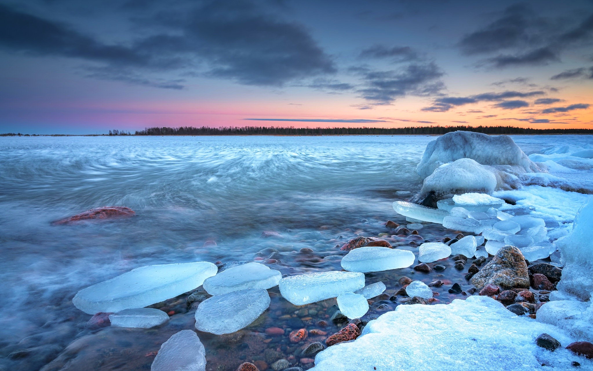 Frozen lake shore with ice chunks at sunset HD Wallpaper