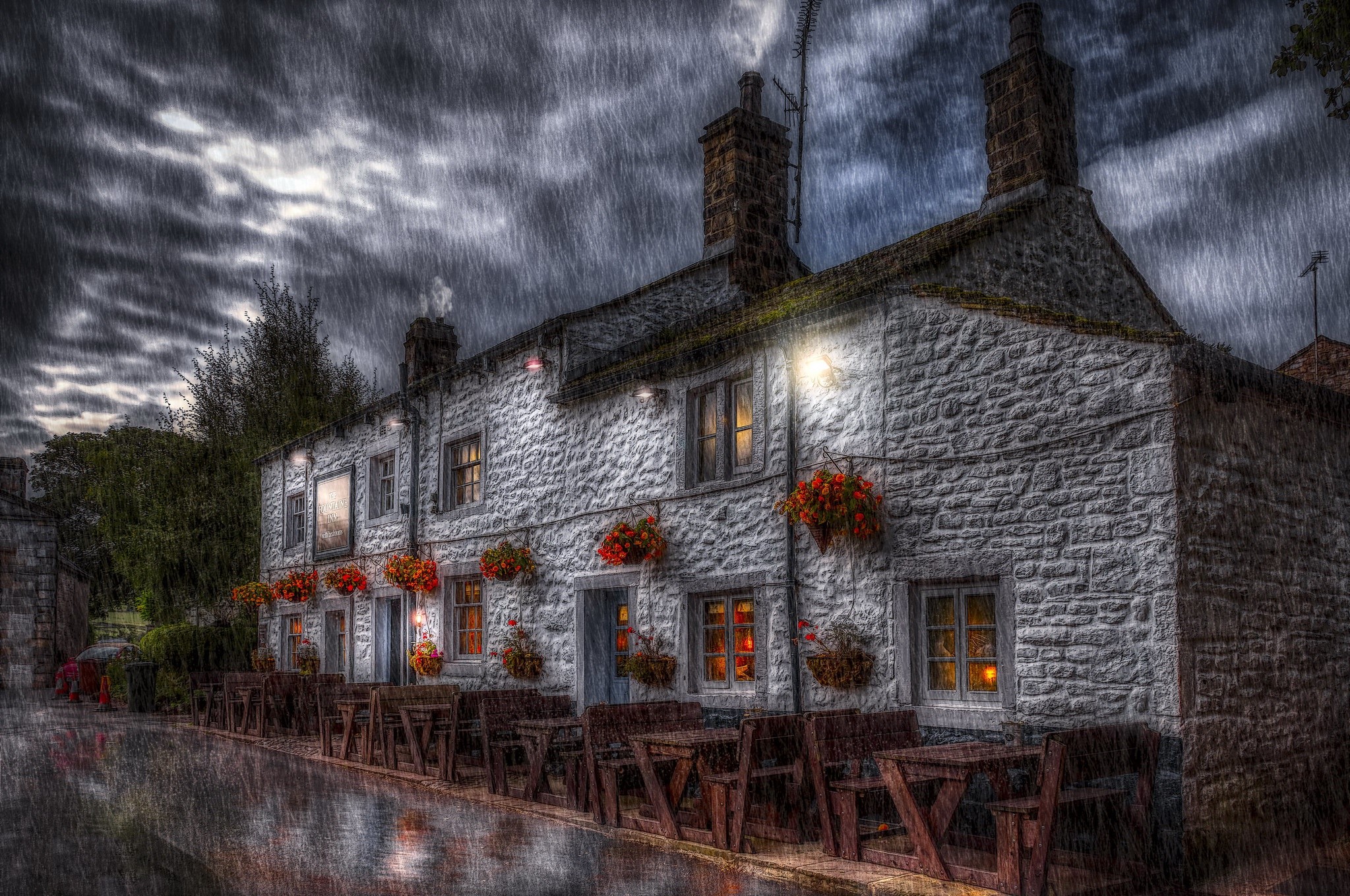 Stone building with outdoor seating in the rain HD Wallpaper