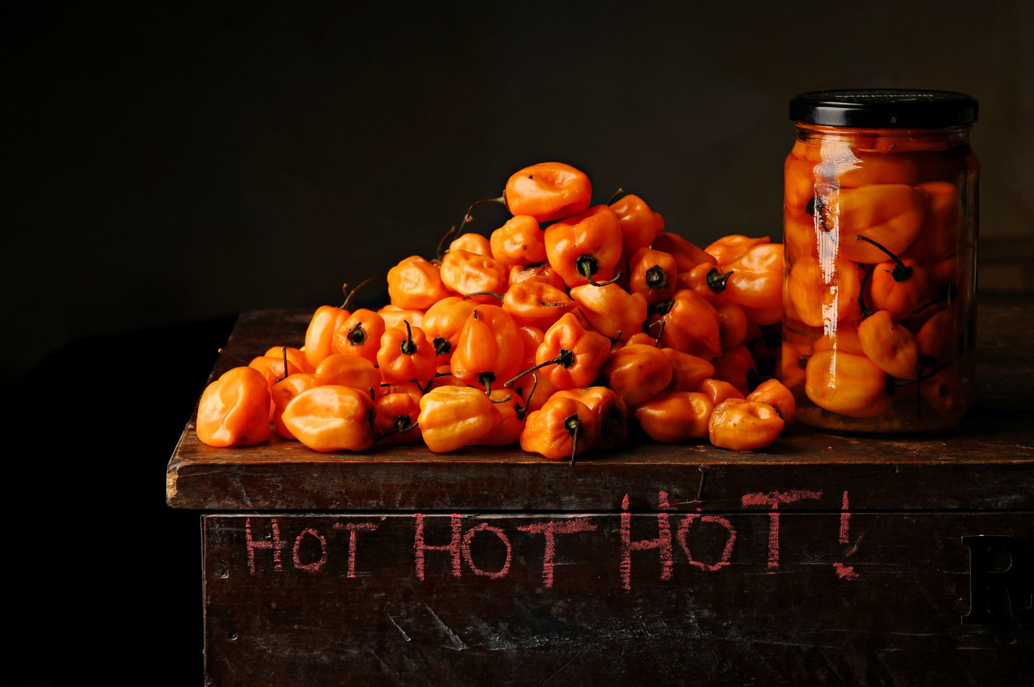 Orange habanero peppers in a jar and a pile HD Wallpaper
