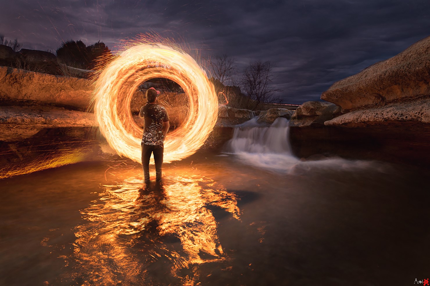 Man creates a fire portal in a river at dusk HD Wallpaper