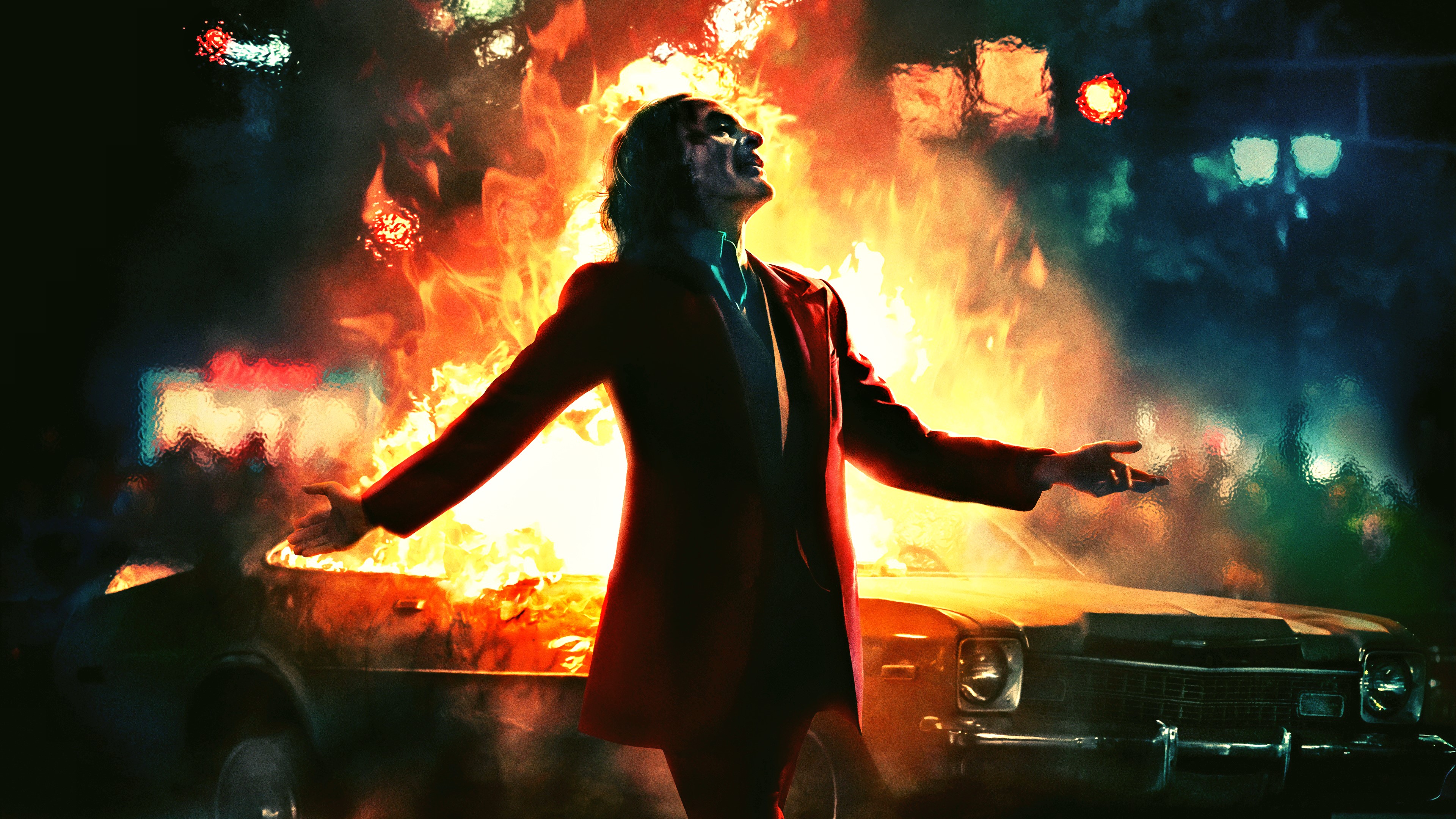 Joker from DC Comics in front of a burning car HD Wallpaper