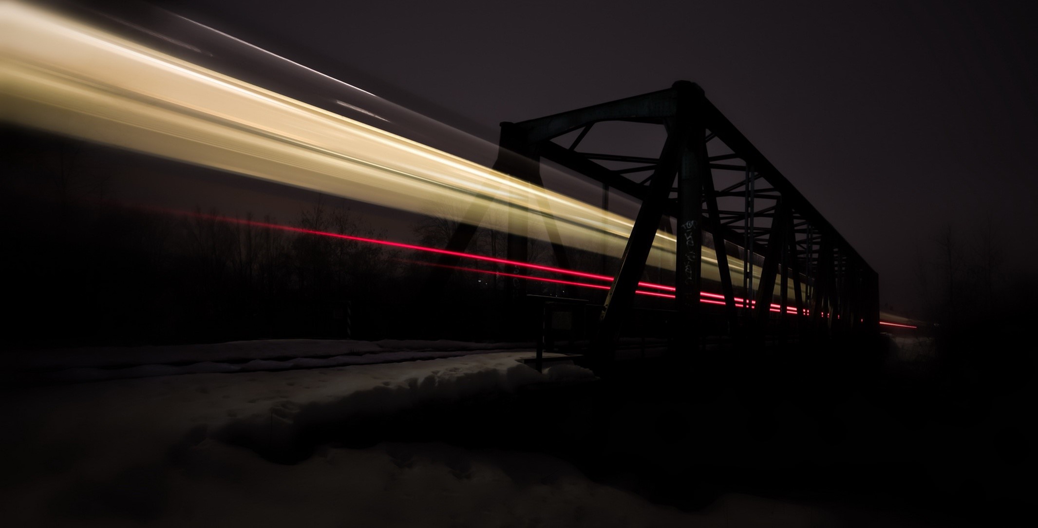 Train light trails passing through a bridge at night HD Wallpaper