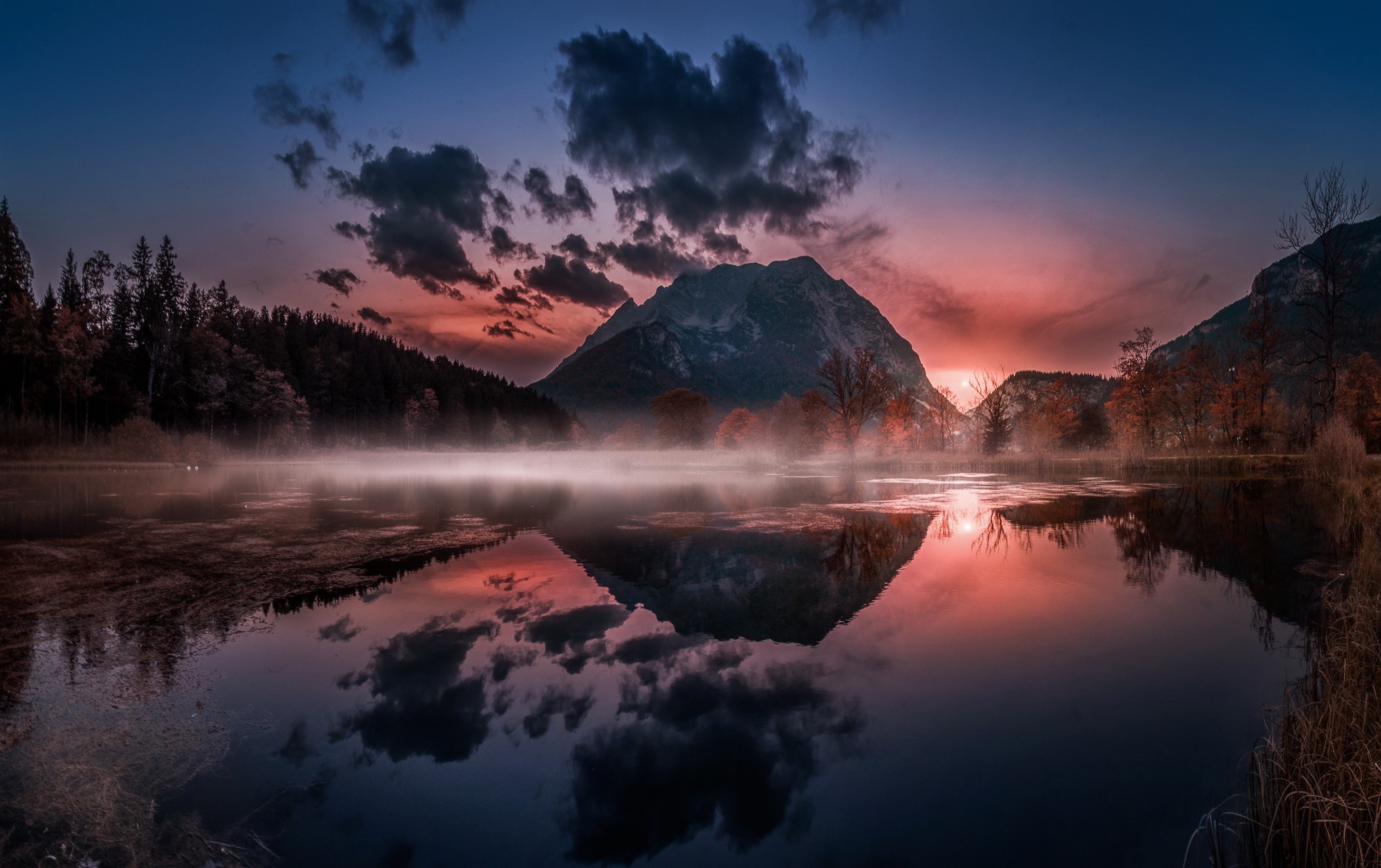 Misty lake reflecting a mountain at sunset HD Wallpaper