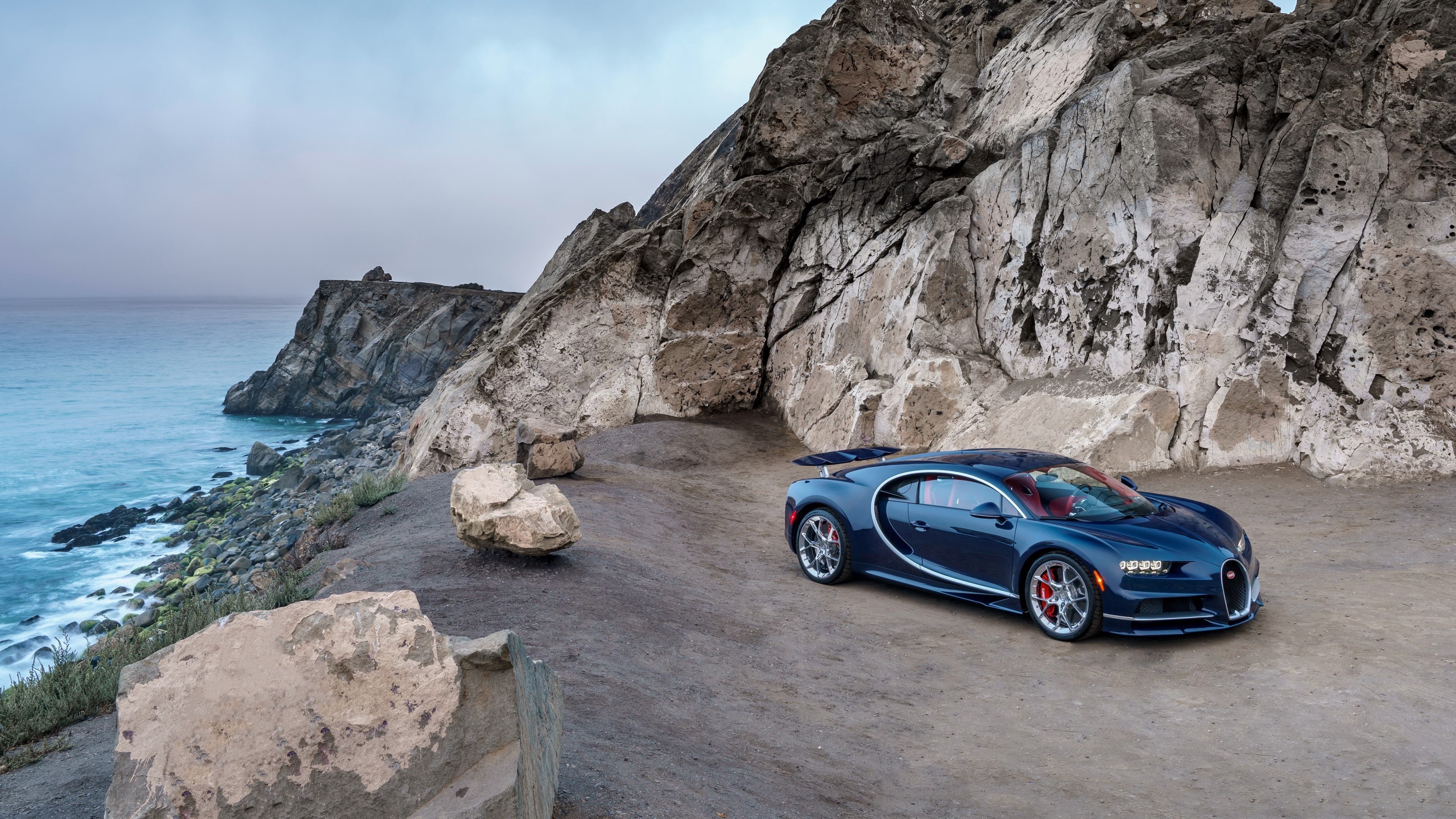 Bugatti Chiron parked on a rocky coastal road HD Wallpaper