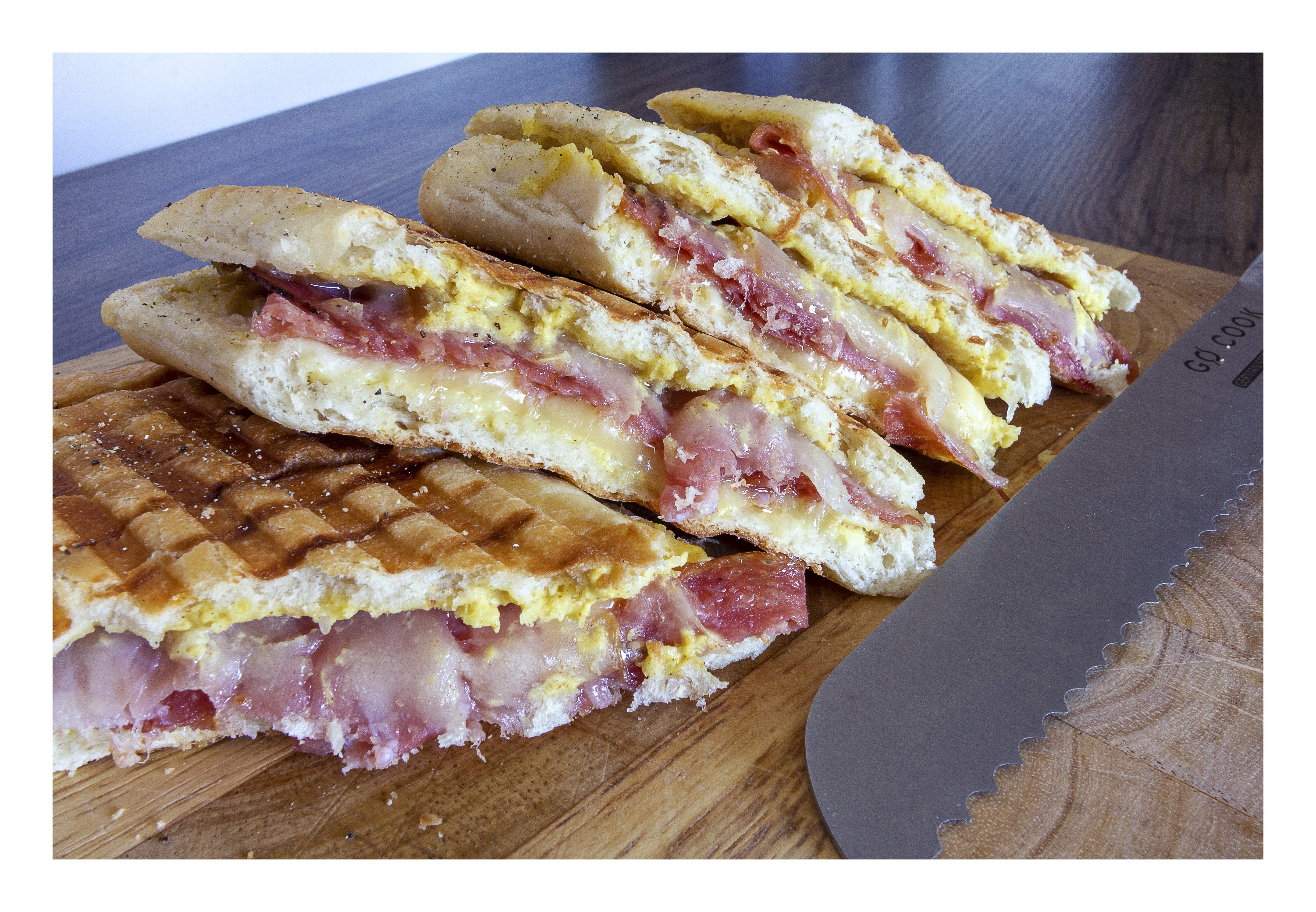 Panini sandwich with meat and cheese on a cutting board HD Wallpaper