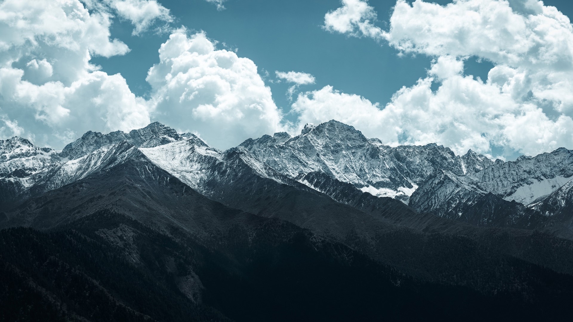 Snowy mountains under a cloudy sky HD Wallpaper