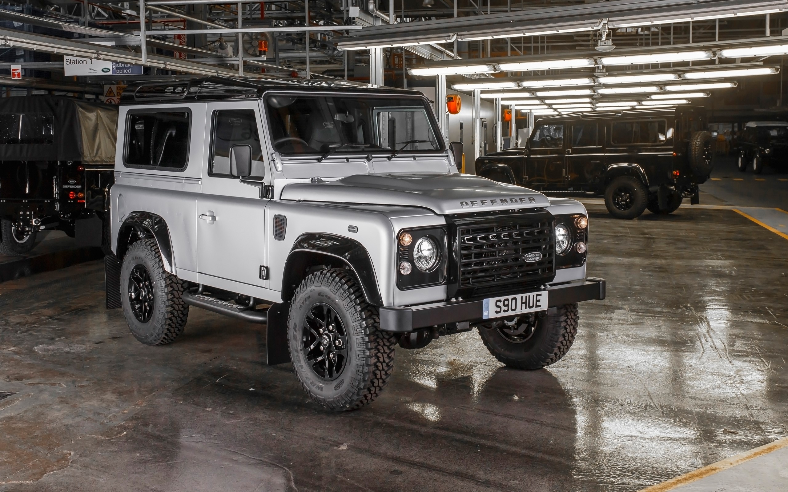 Silver Land Rover Defender in a factory HD Wallpaper