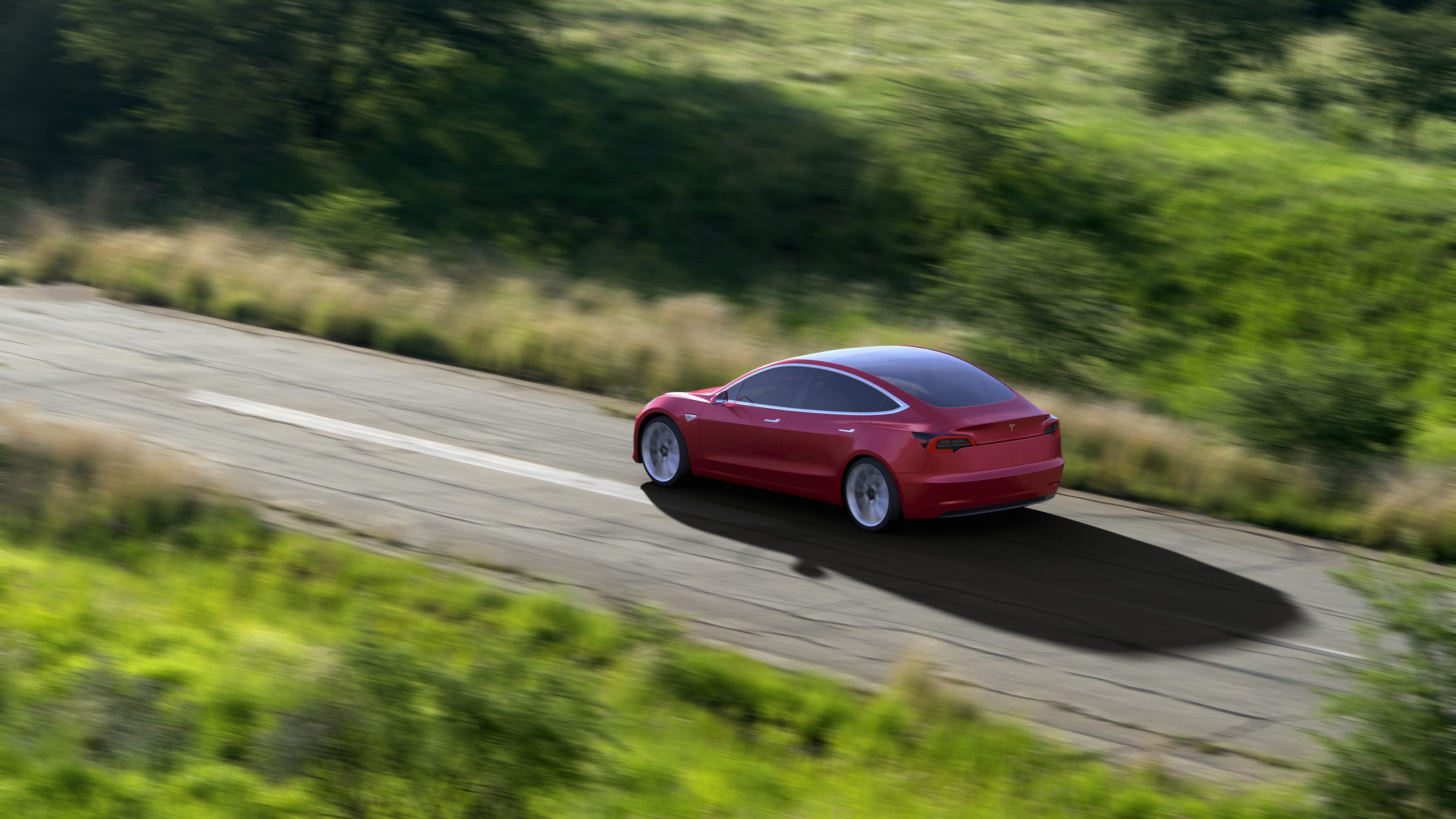 Red Tesla Model 3 driving on a road HD Wallpaper