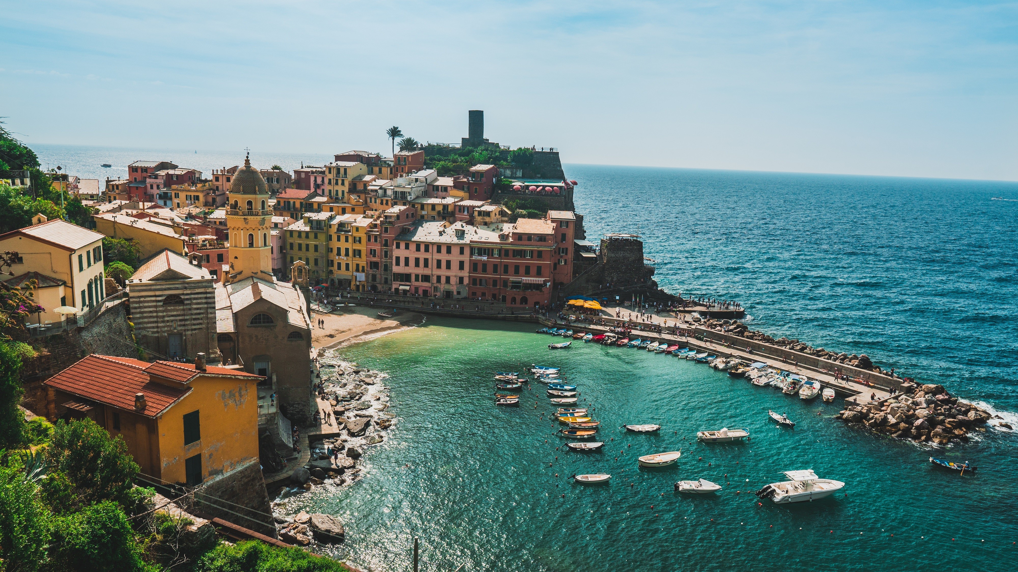 Vernazza, Italy: Colorful buildings on a cliff overlooking the sea with boats HD Wallpaper
