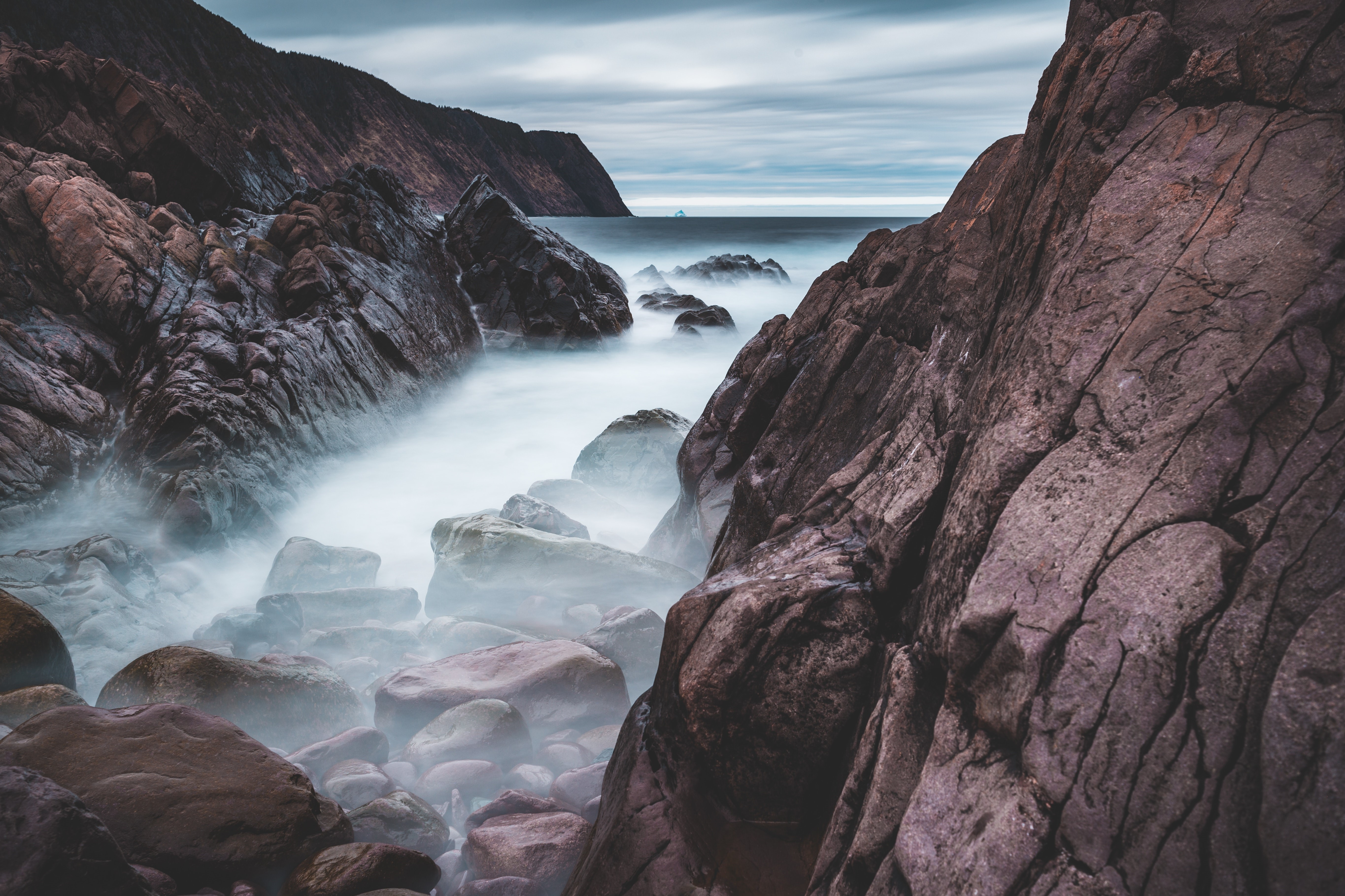 Long exposure of rocky coast with misty ocean HD Wallpaper