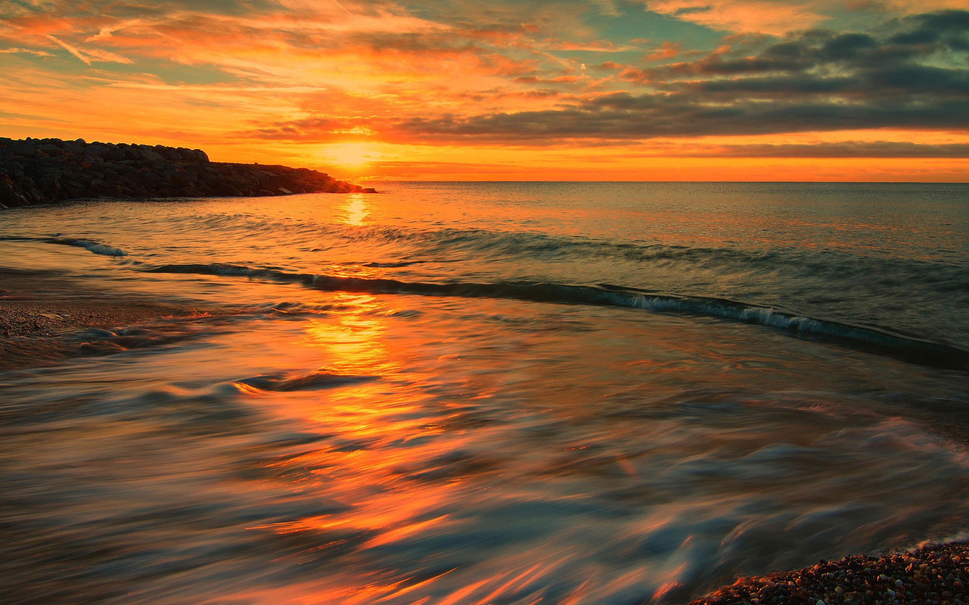 Sunset over the ocean with waves on the beach HD Wallpaper