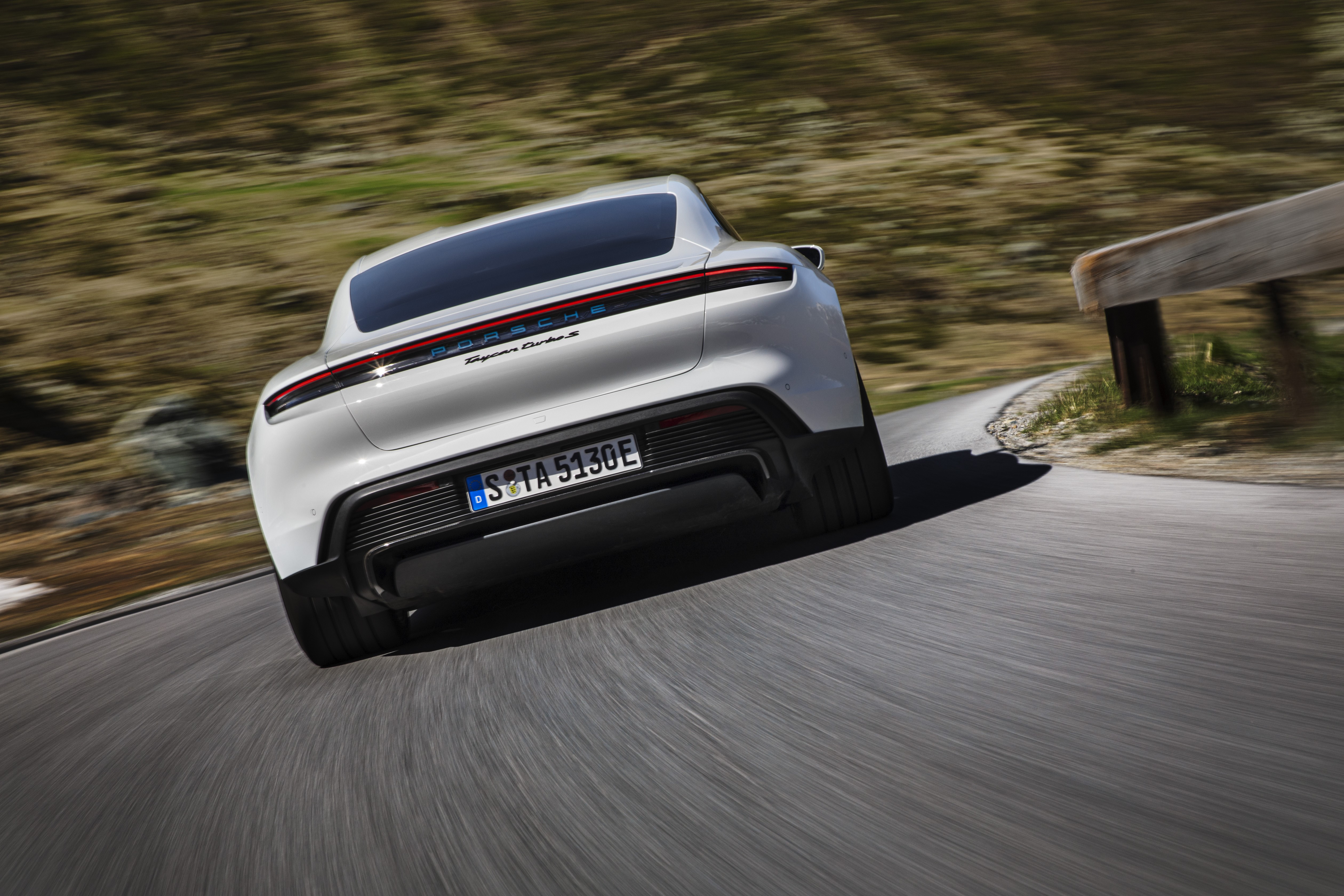Porsche Taycan Turbo S driving on a mountain road HD Wallpaper