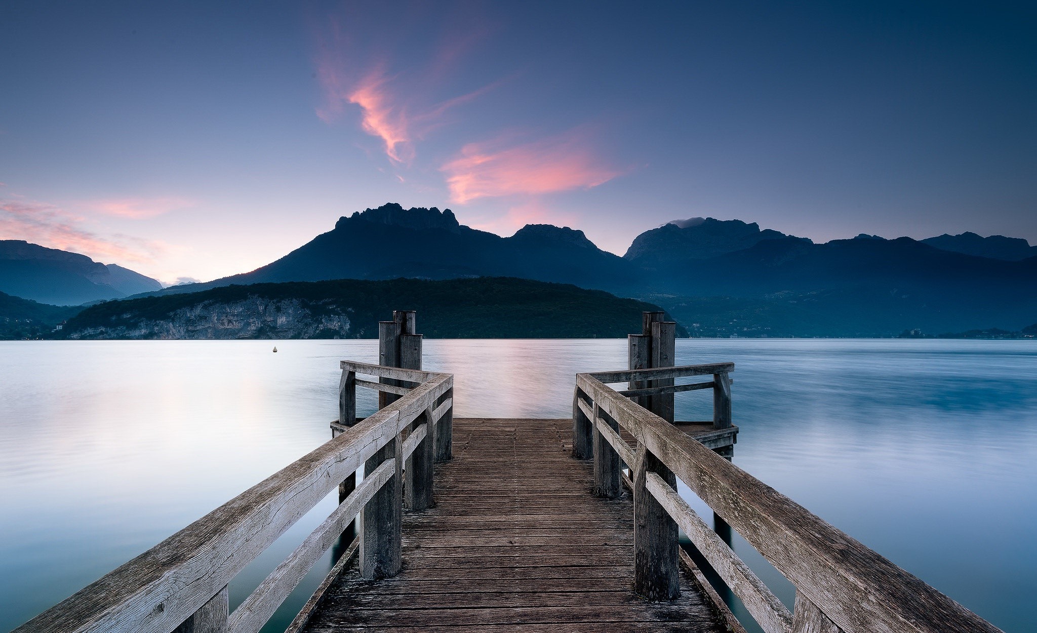 Wooden pier on a calm lake with mountains at dusk HD Wallpaper