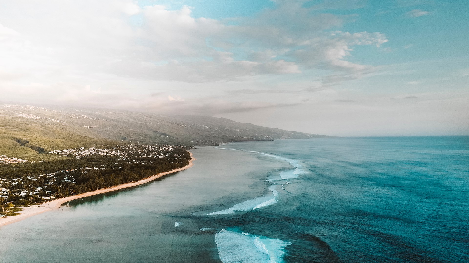 Aerial view of Reunion Island coastline with mountains and ocean HD Wallpaper
