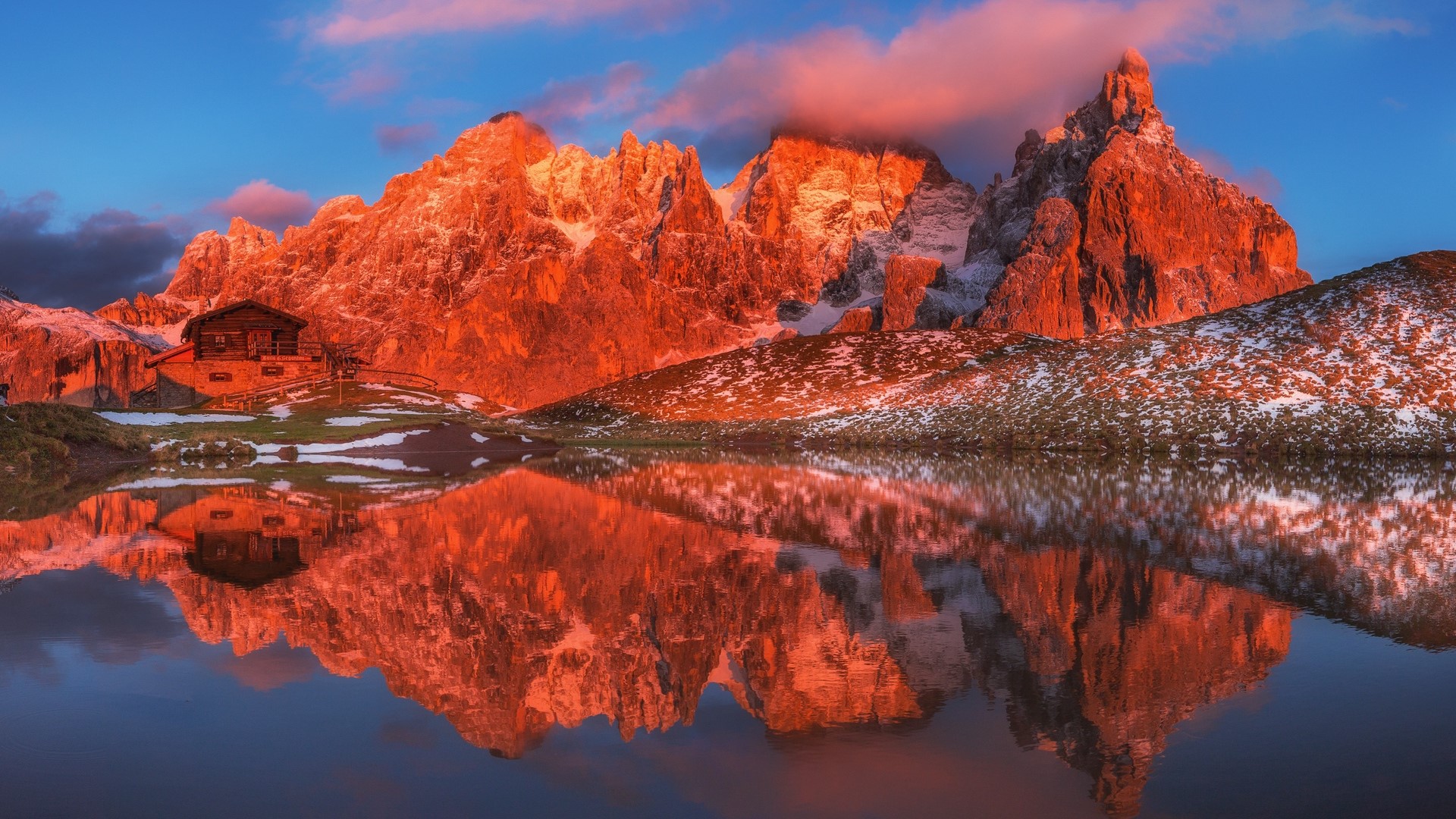 Mountain cabin reflected in a lake at sunrise HD Wallpaper