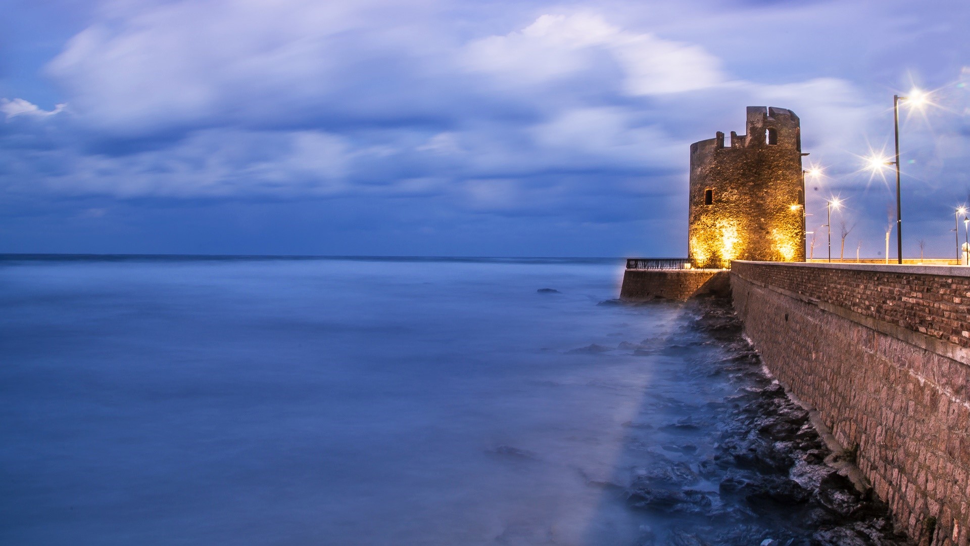 Tower by the sea in Nuoro, Sardinia, Italy at dusk HD Wallpaper