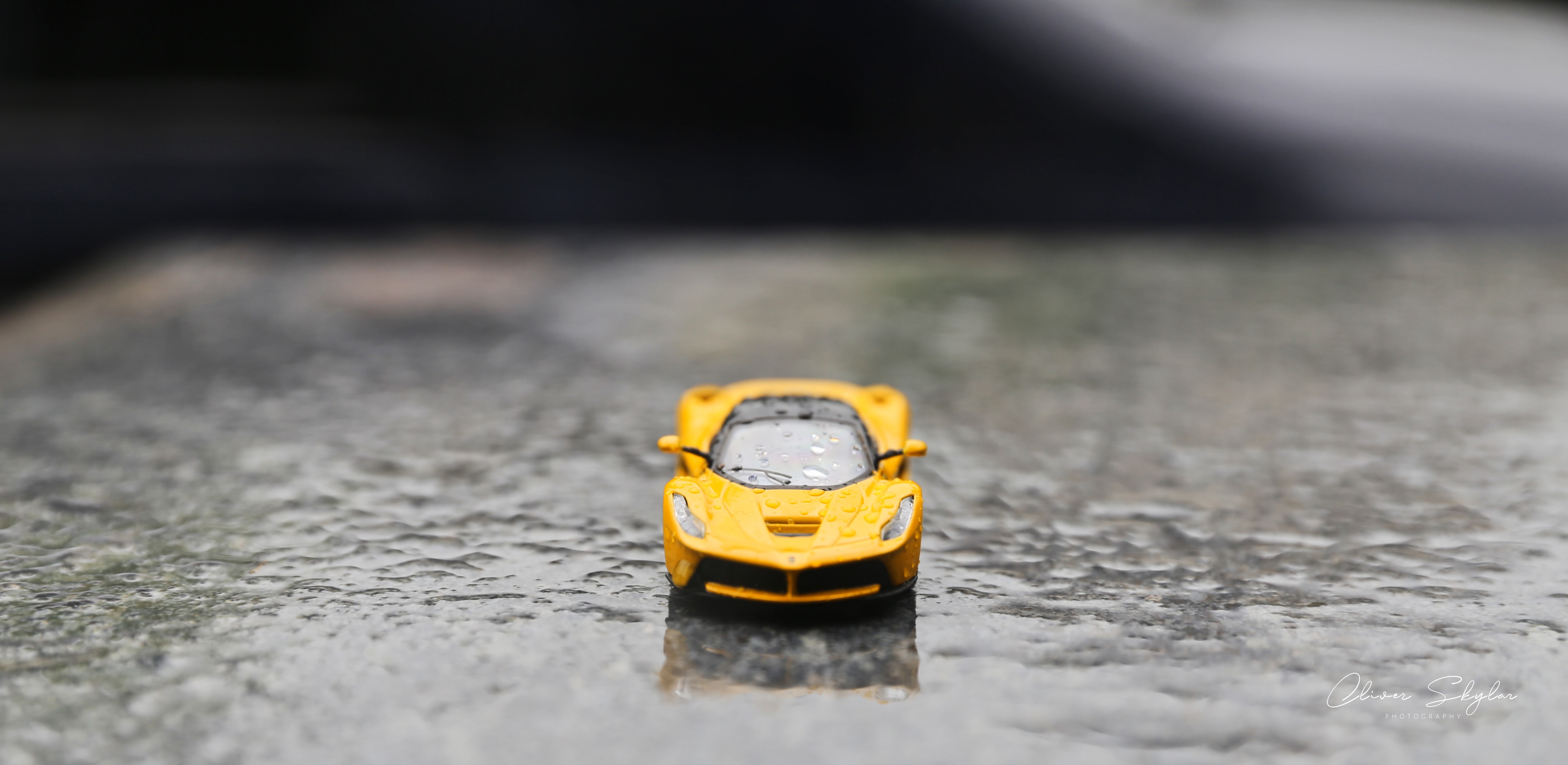 Yellow Ferrari LaFerrari toy car on wet surface HD Wallpaper